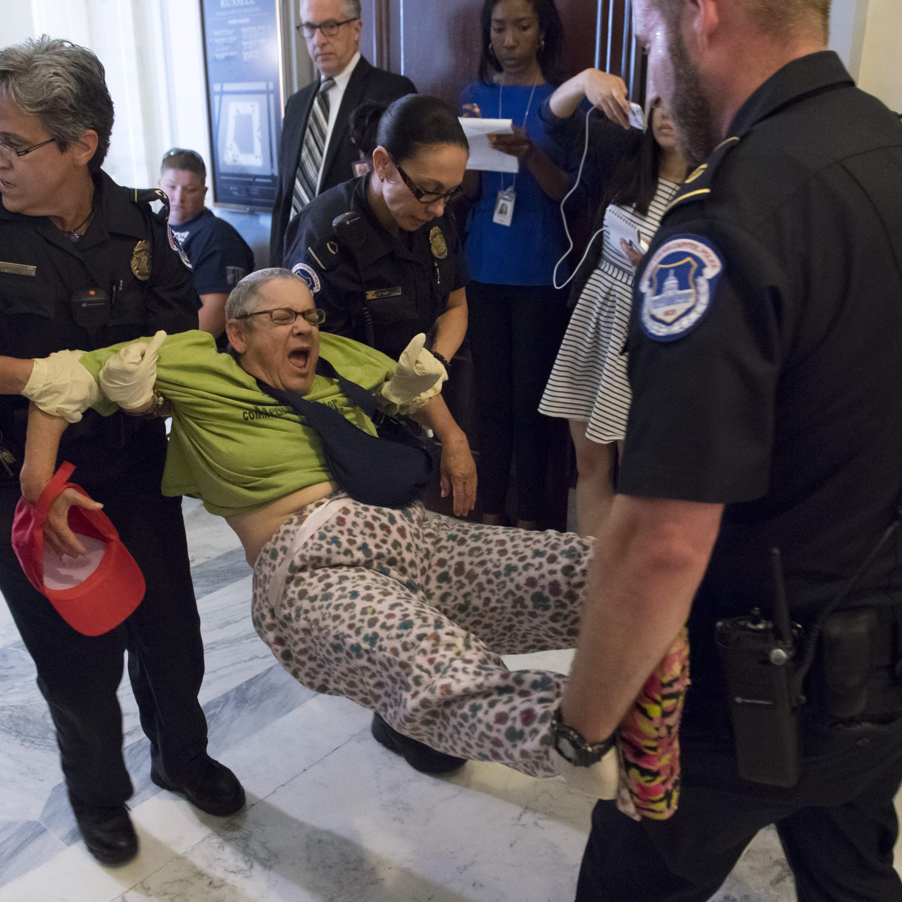 US Capitol Police arrest a protestor against the Senate Republican's draft healthcare bill outside the office of Senate Majority Leader Mitch McConnell, Republican of Kentucky, on Capitol Hill in Washington, DC, June 22, 2017.