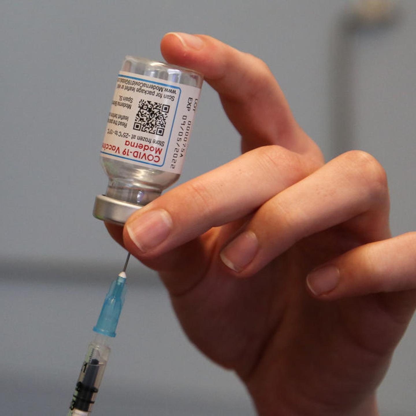 A health worker draws the Moderna COVID-19 vaccine as she