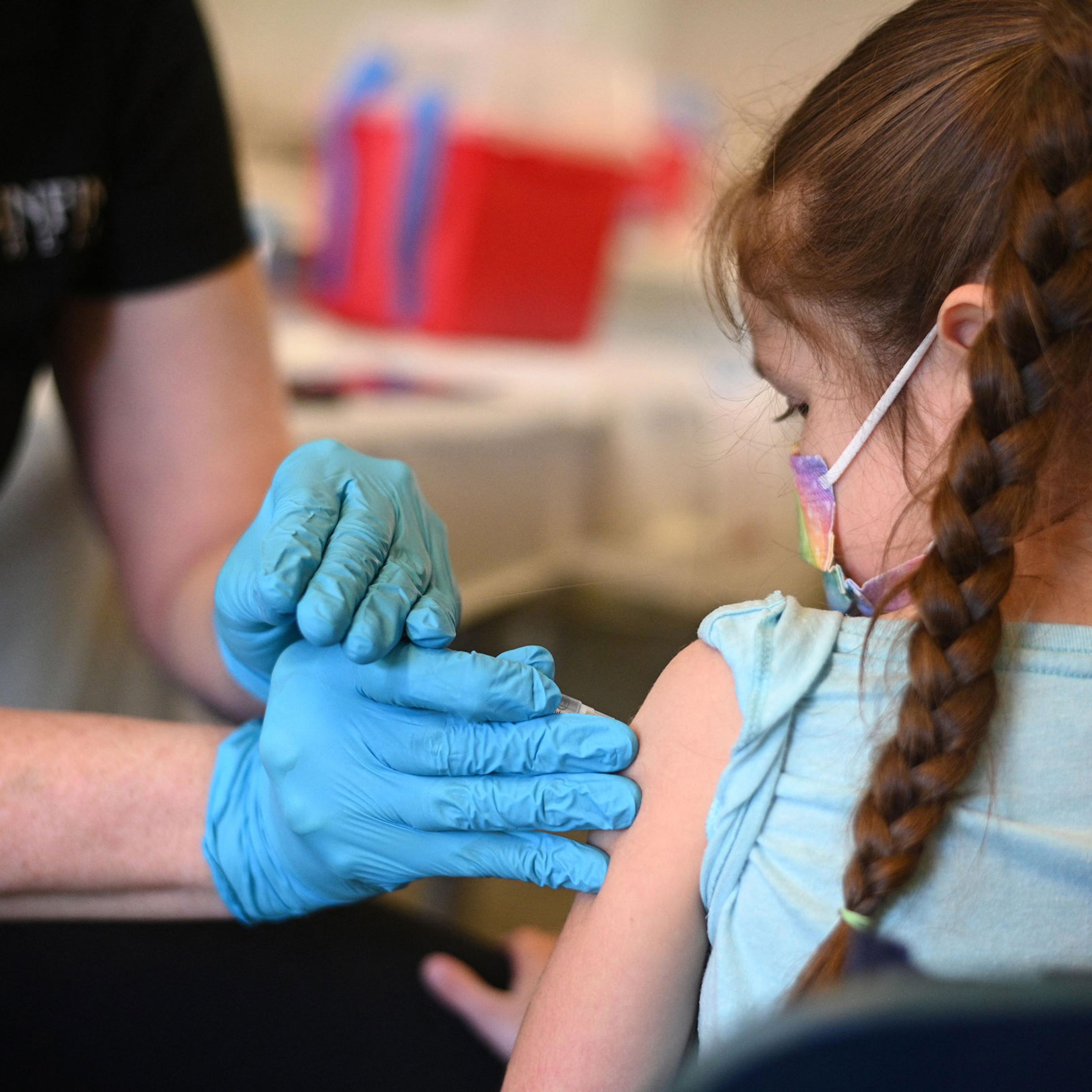 A nurse administers a pediatric dose of the Covid-19 vaccine to a girl at a L.A. Care Health Plan vaccination clinic