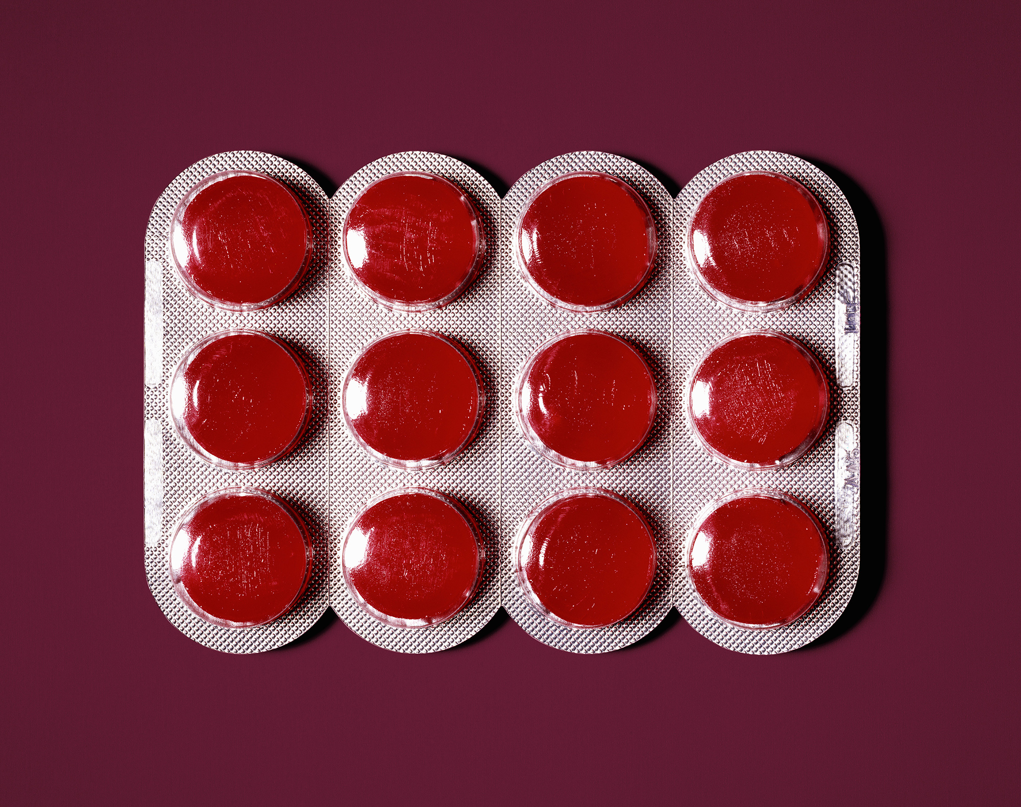 Red lozenges in blister pack, close-up