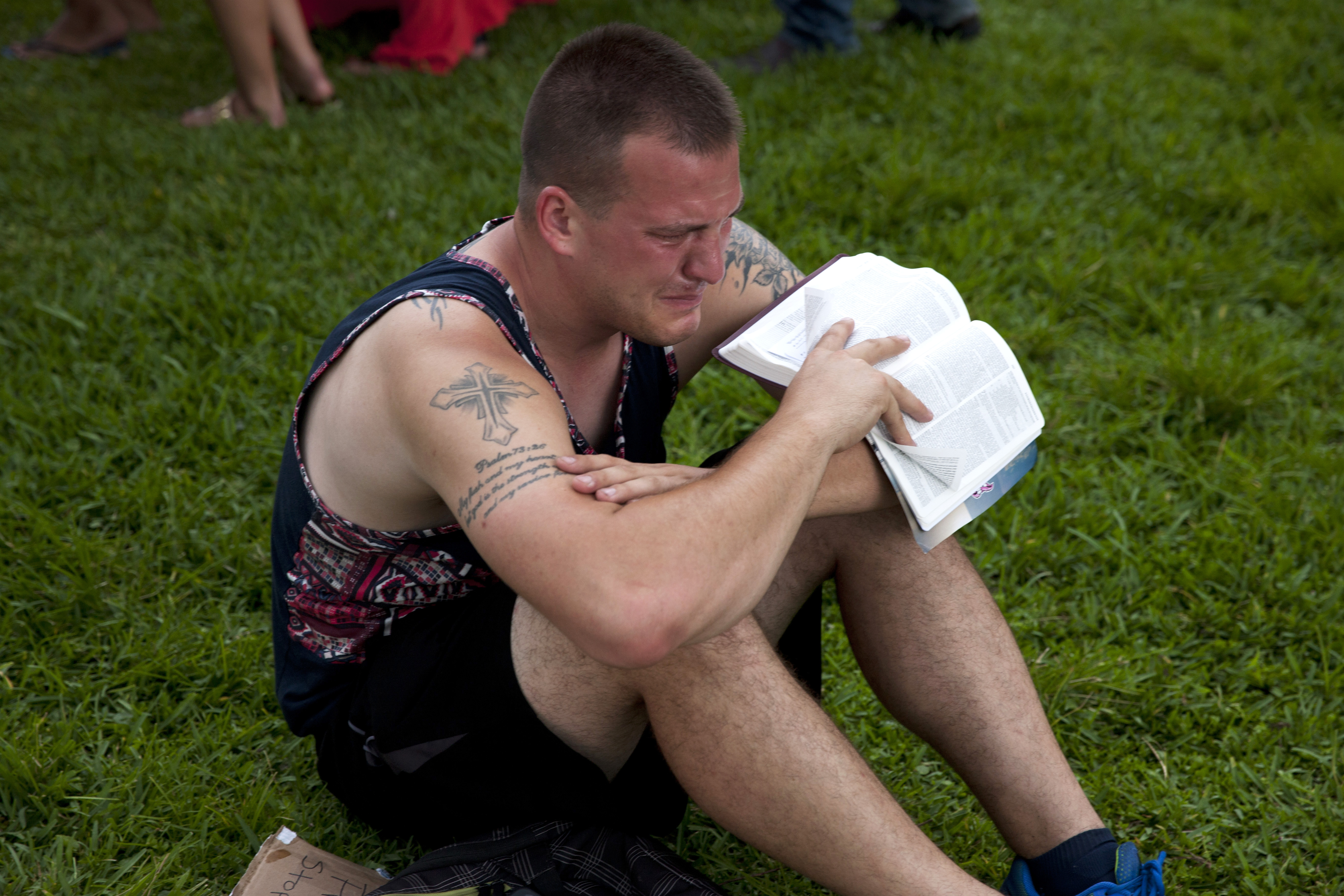 A mourner attends a makeshift vigil and a moment of silence for victims of the Pulse nightclub shooting in Orlando, Fla., on June 12, 2016.