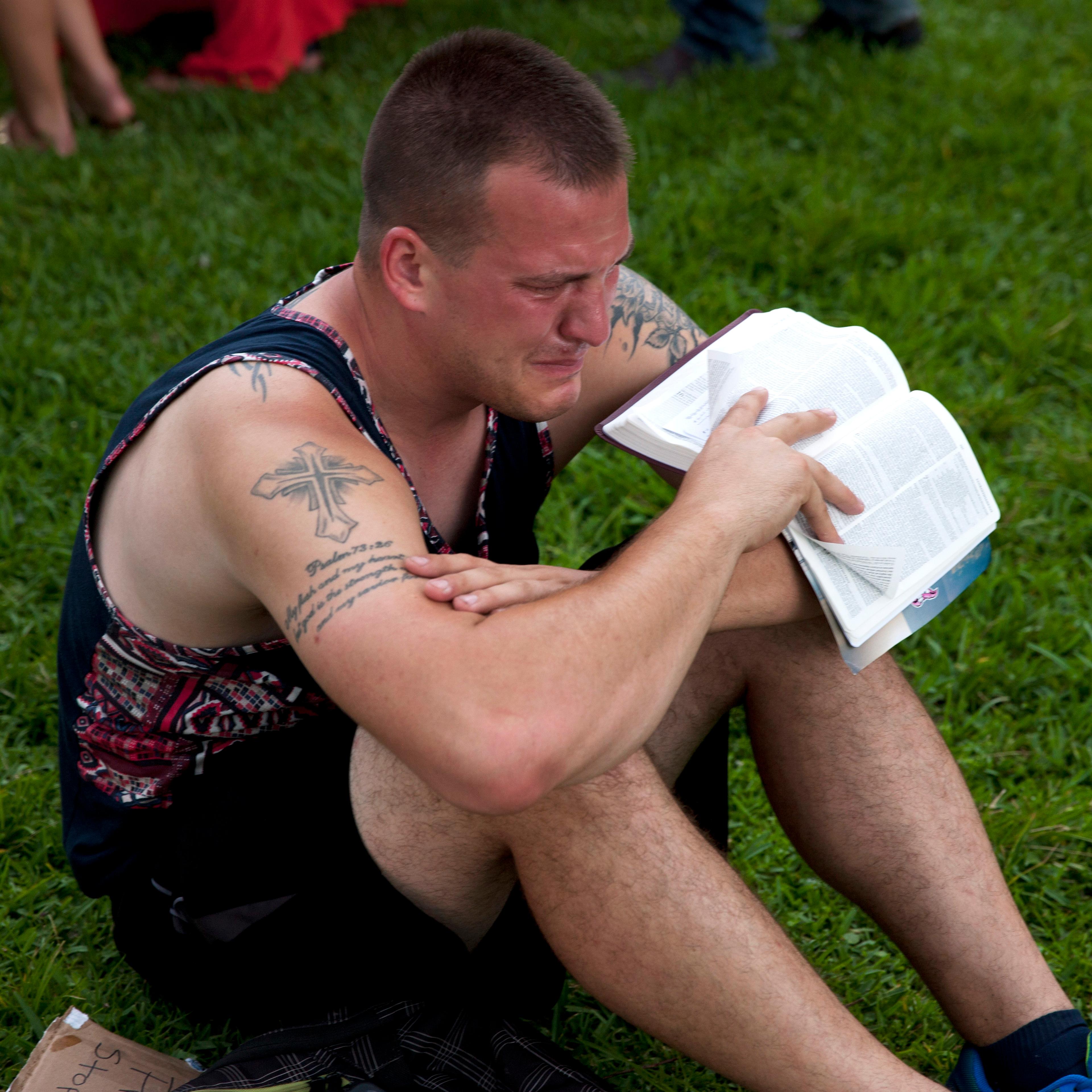 A mourner attends a makeshift vigil and a moment of silence for victims of the Pulse nightclub shooting in Orlando, Fla., on June 12, 2016.