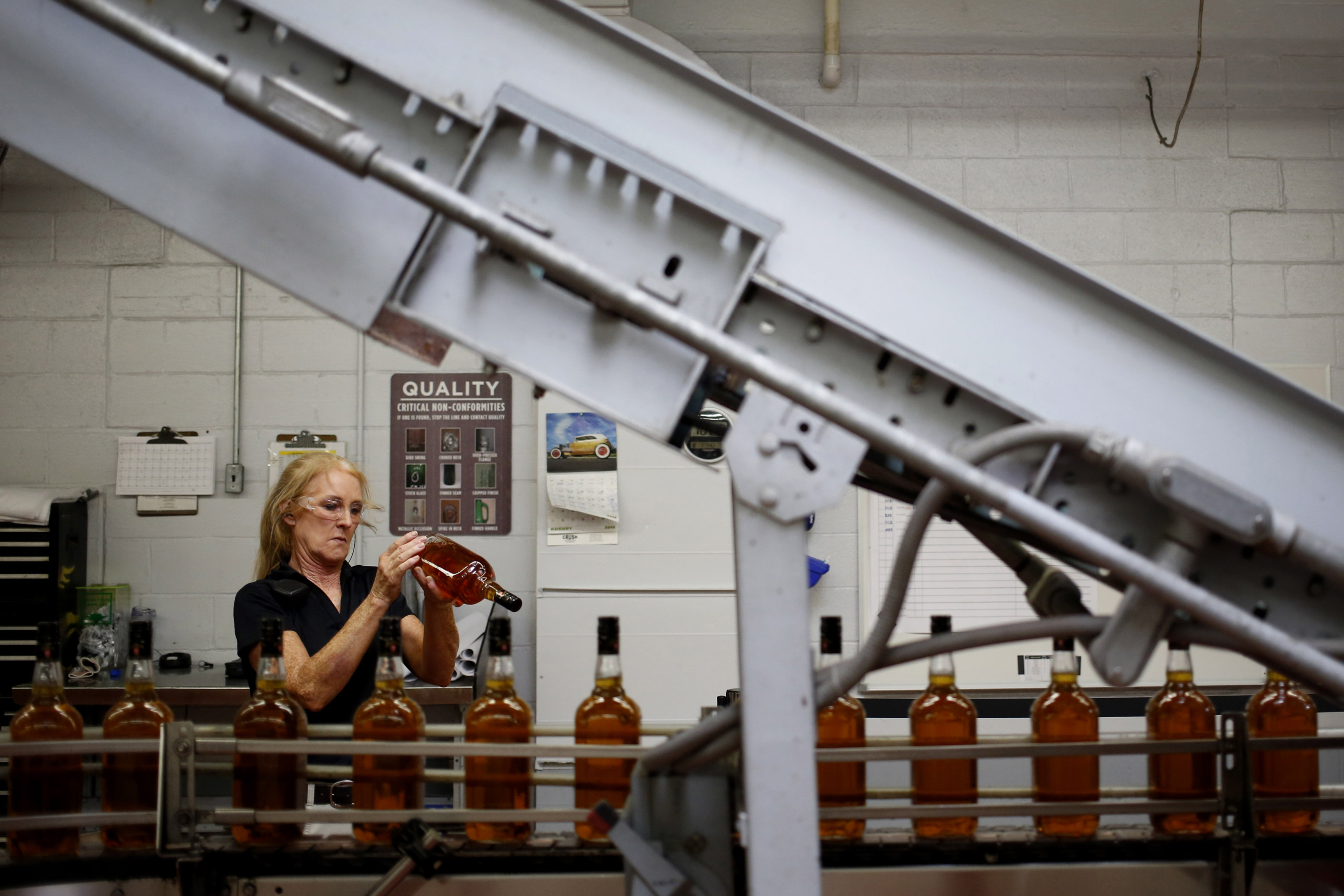 Distillery technician Laura Elden performs quality control along the Jim Beam Maple bourbon bottling line at the Beam Inc. distillery in Clermont, Kentucky, U.S., on Thursday, Aug. 1, 2013.