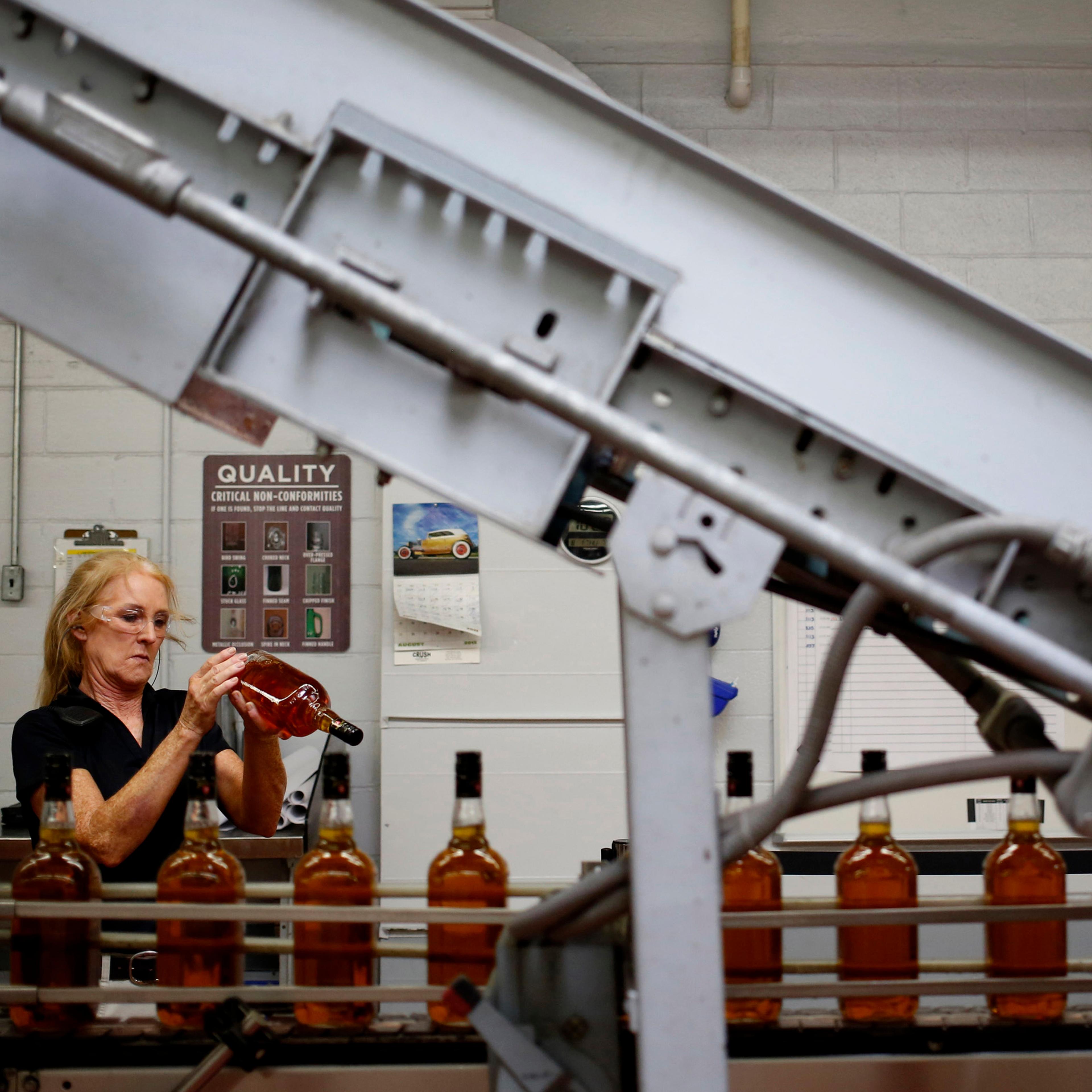 Distillery technician Laura Elden performs quality control along the Jim Beam Maple bourbon bottling line at the Beam Inc. distillery in Clermont, Kentucky, U.S., on Thursday, Aug. 1, 2013.