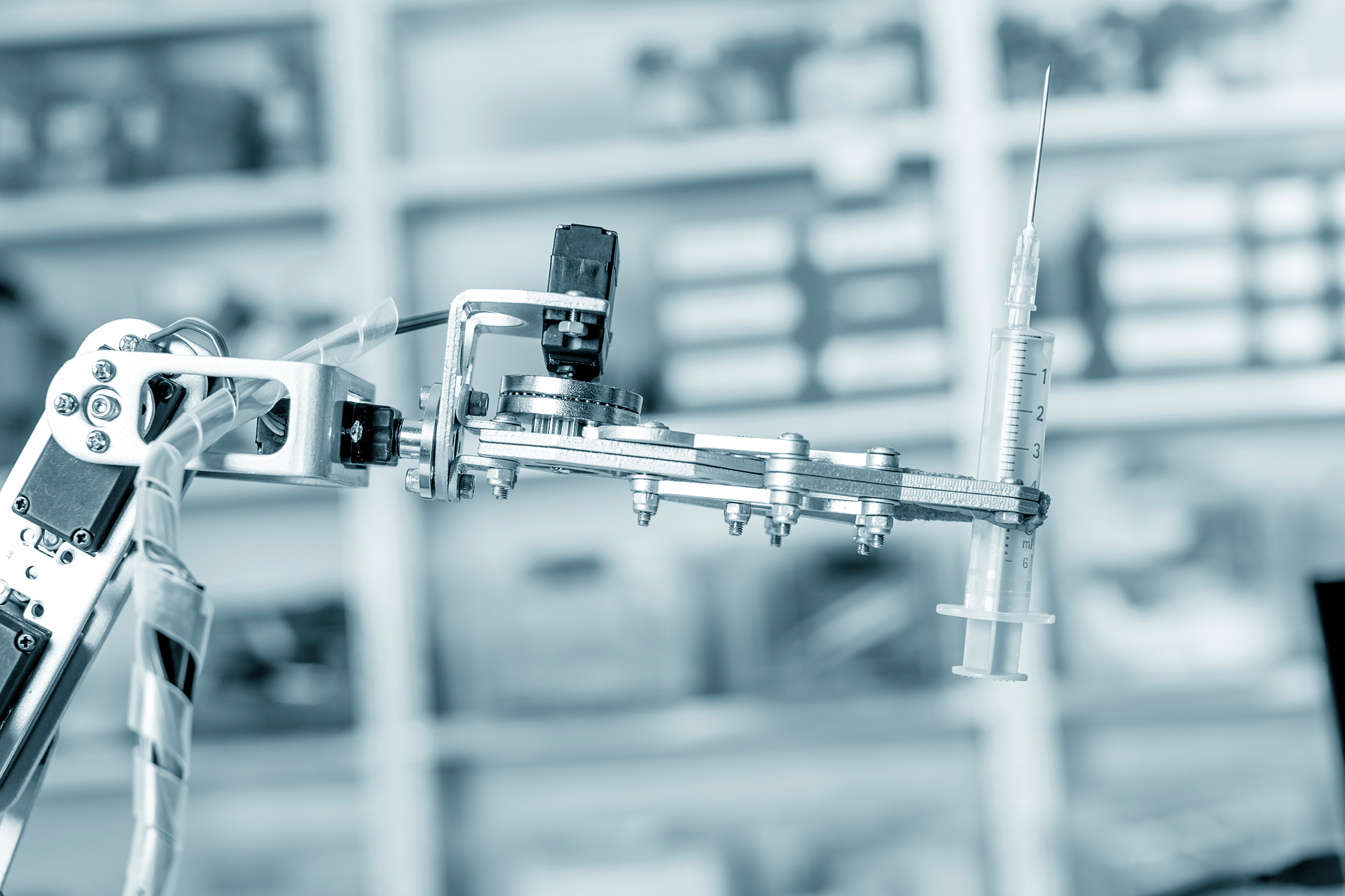 Robotic hand holding syringe.