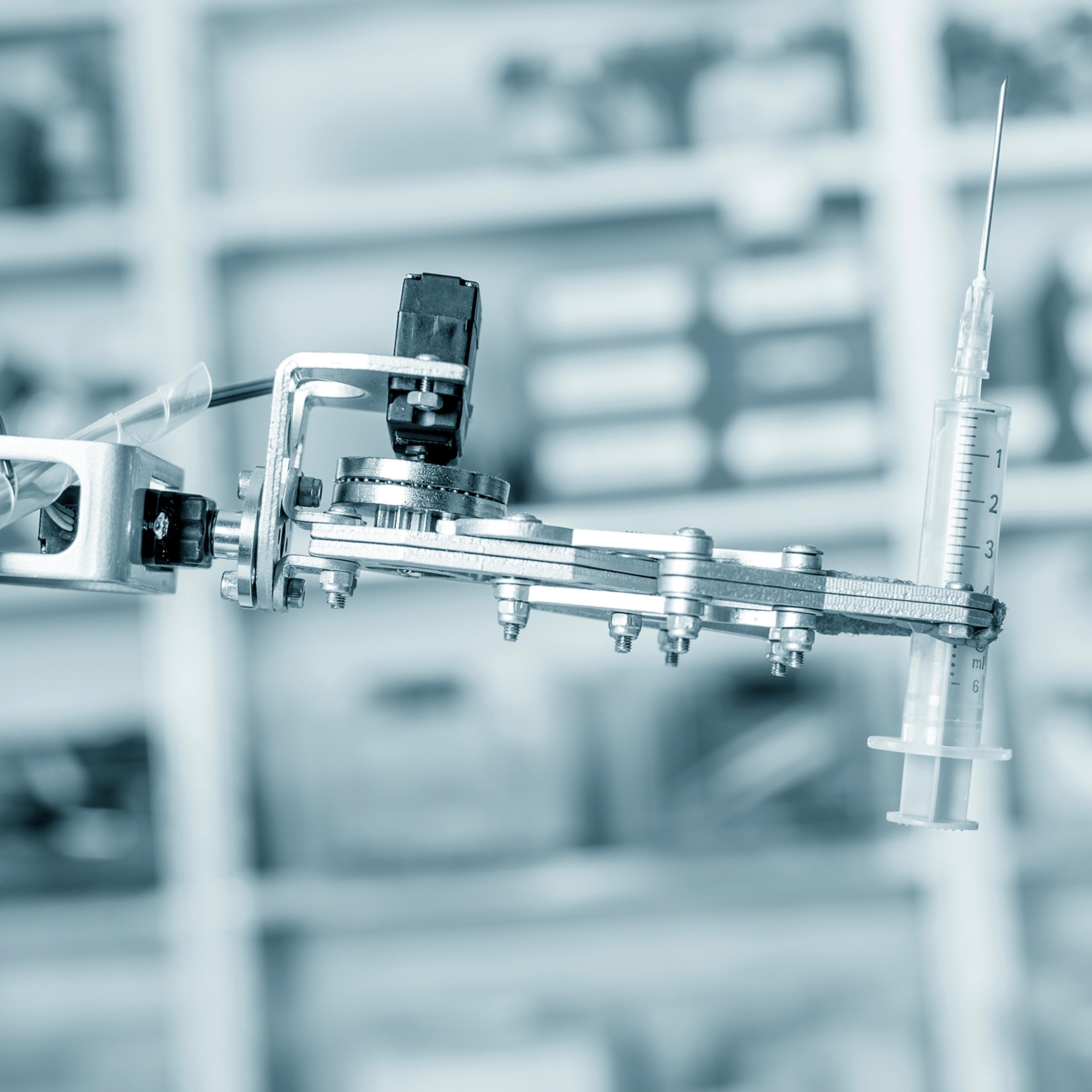 Robotic hand holding syringe.