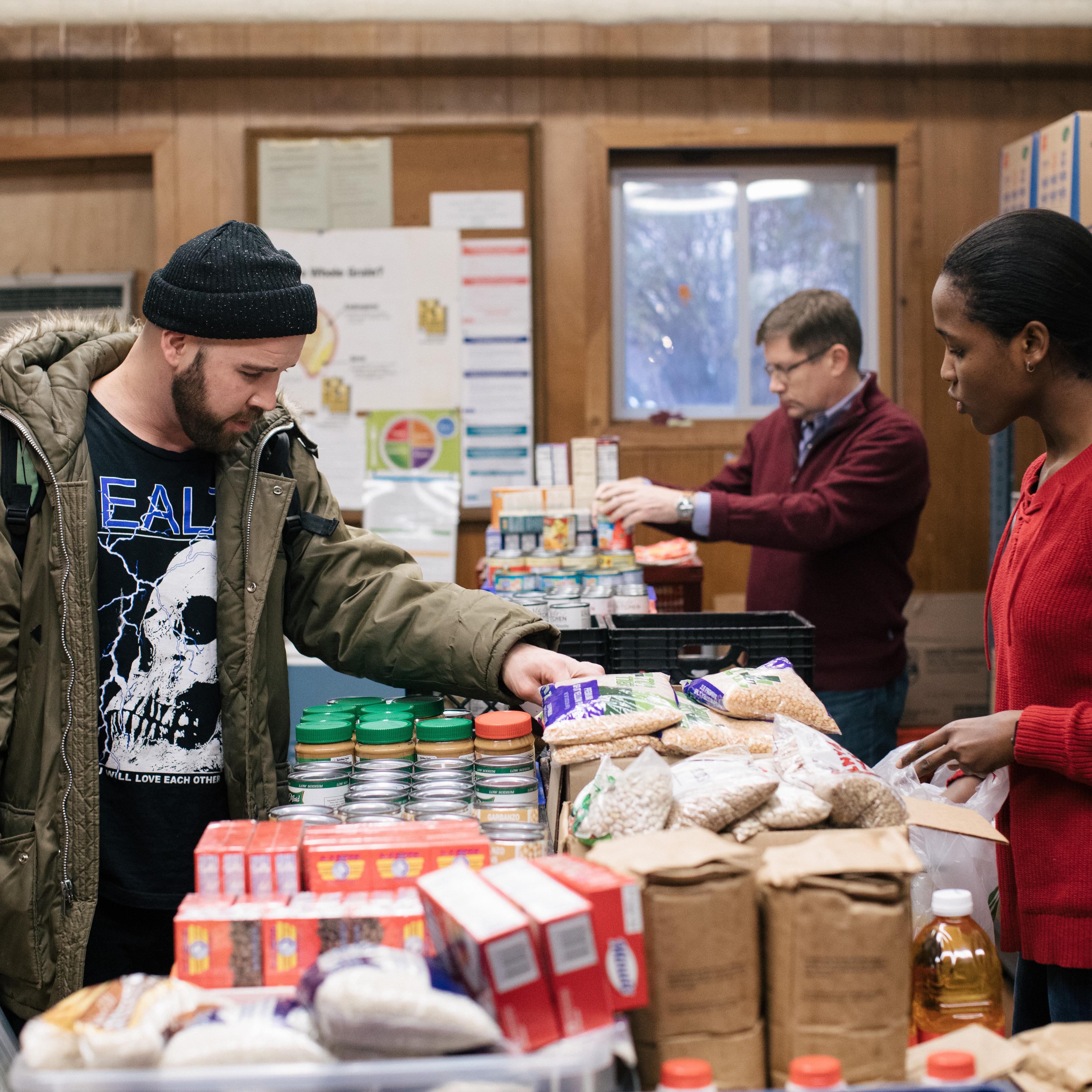 A volunteer helps a patron, on the left, at the St. Ignatius Church food pantry on Chicago’s North Side, part of the Greater Chicago Food Depository’s network.