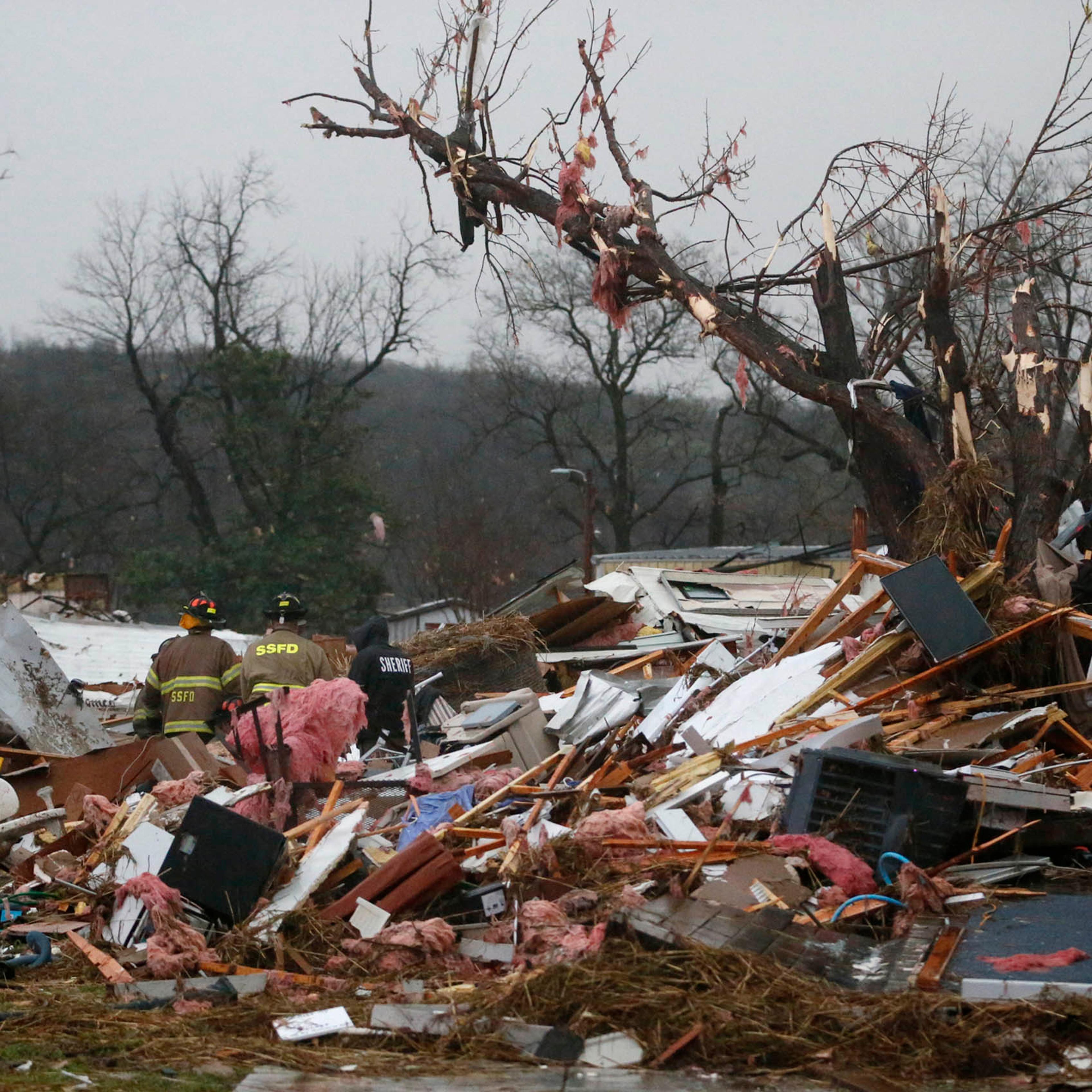 First responders work to free a man from a rubble pile after a round of severe weather hit a trailer park in Sand Springs, Okla., on March 25, 2015.
