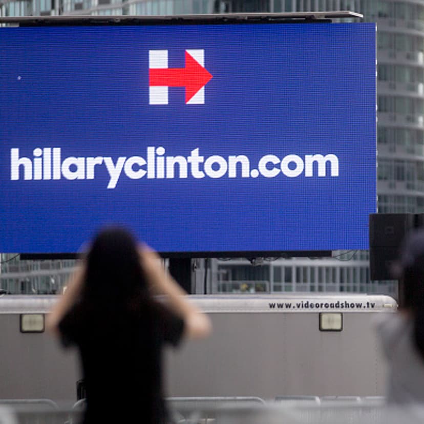 Visitors take a photograph of a Hillaryclinton.com billboard before the first 2016 Democratic candidate Hillary Clinton campaign rally at Four Freedoms Park on Roosevelt Island in New York, U.S., on Saturday, June 13, 2015.