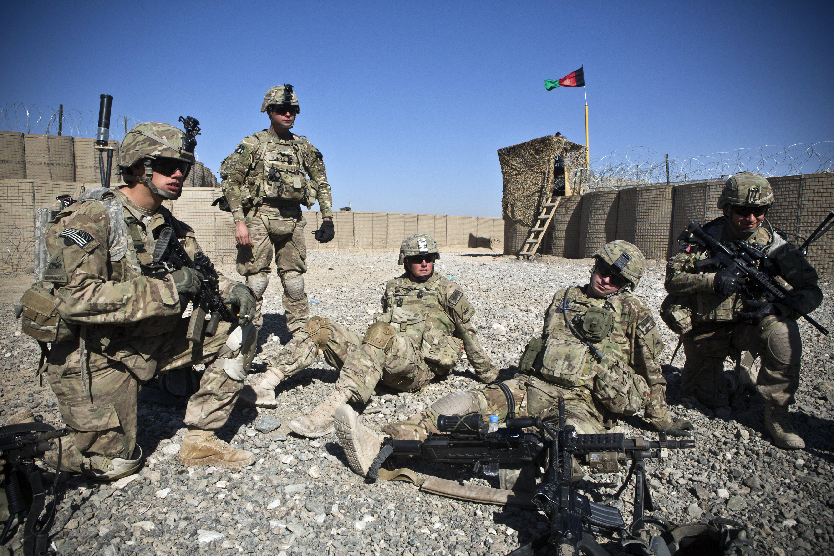 Soldiers with the U.S. Army's  Bravo Company, 1st Battalion, 36th Infantry Regiment rest in an Afgan National Police compound before going on patrol near Command Outpost AJK (short for Azim-Jan-Kariz - a near-by village) in Maiwand District