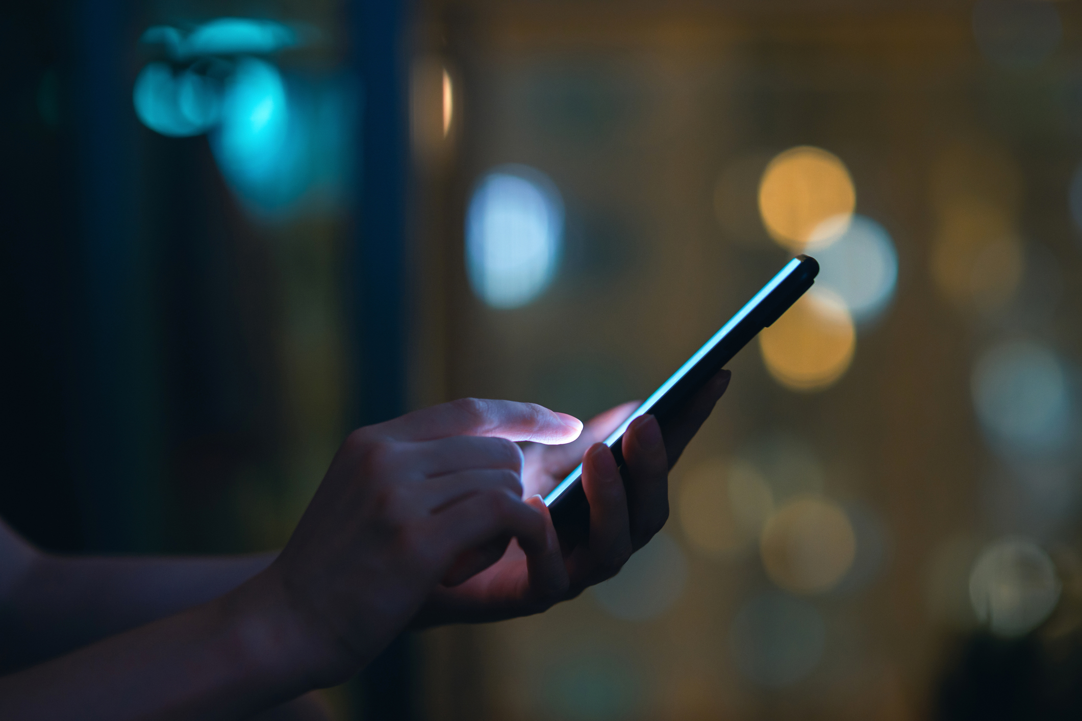 Close up of hand using smartphone in the dark