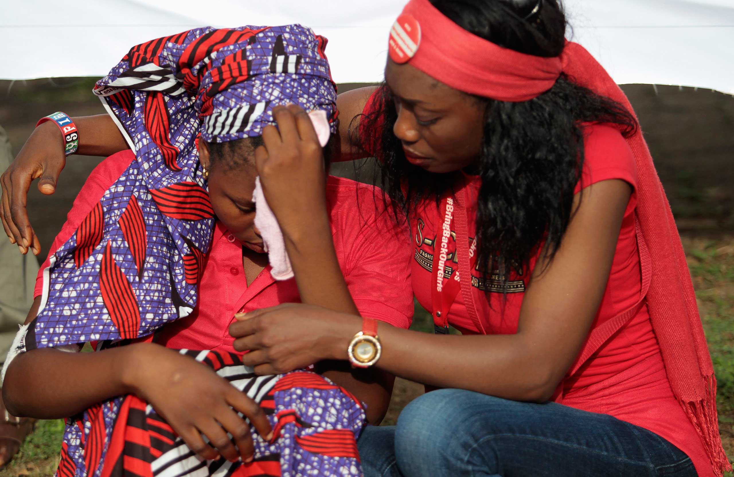 Rebecca, one of the girls that escaped from the Boko Haram camp is comforted during a protest march, organized by the Abuja "Bring Back Our Girls" protest group to the Presidential Villa, in Abuja