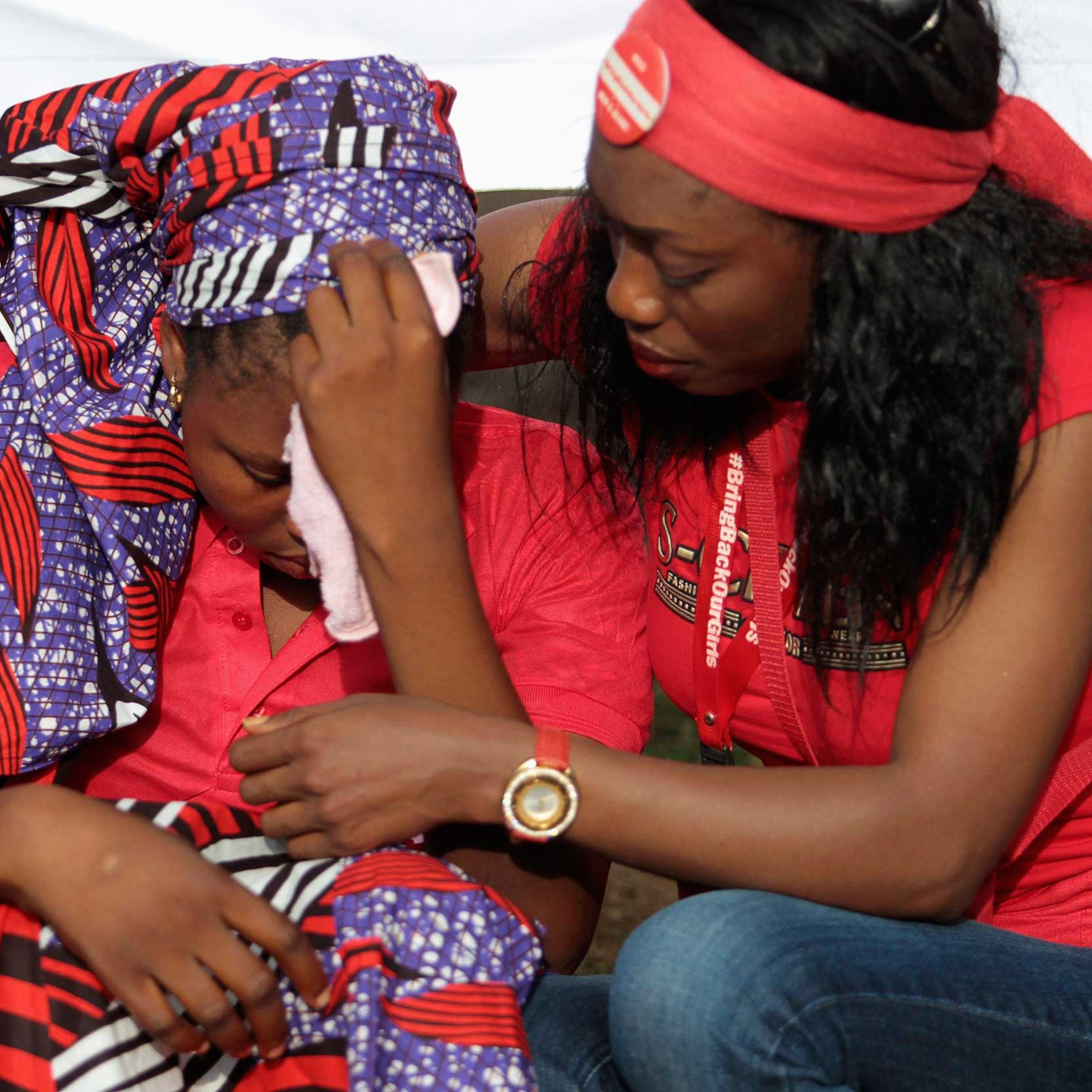 Rebecca, one of the girls that escaped from the Boko Haram camp is comforted during a protest march, organized by the Abuja "Bring Back Our Girls" protest group to the Presidential Villa, in Abuja