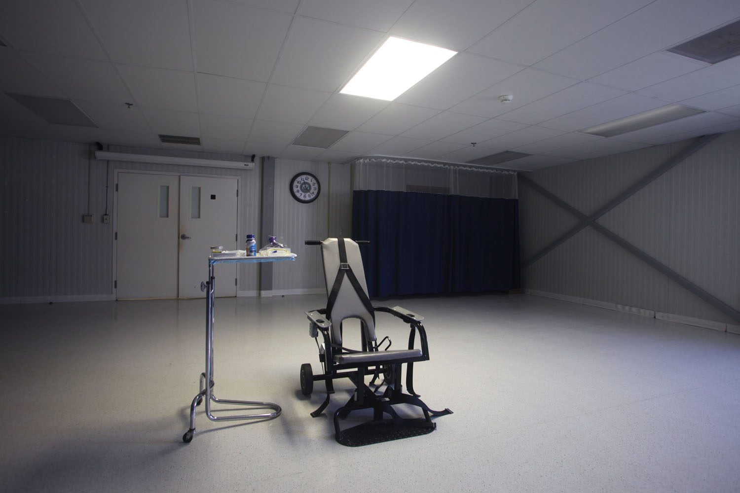A restraining chair and force-feeding apparatus on display in an empty room of the detainee hospital.