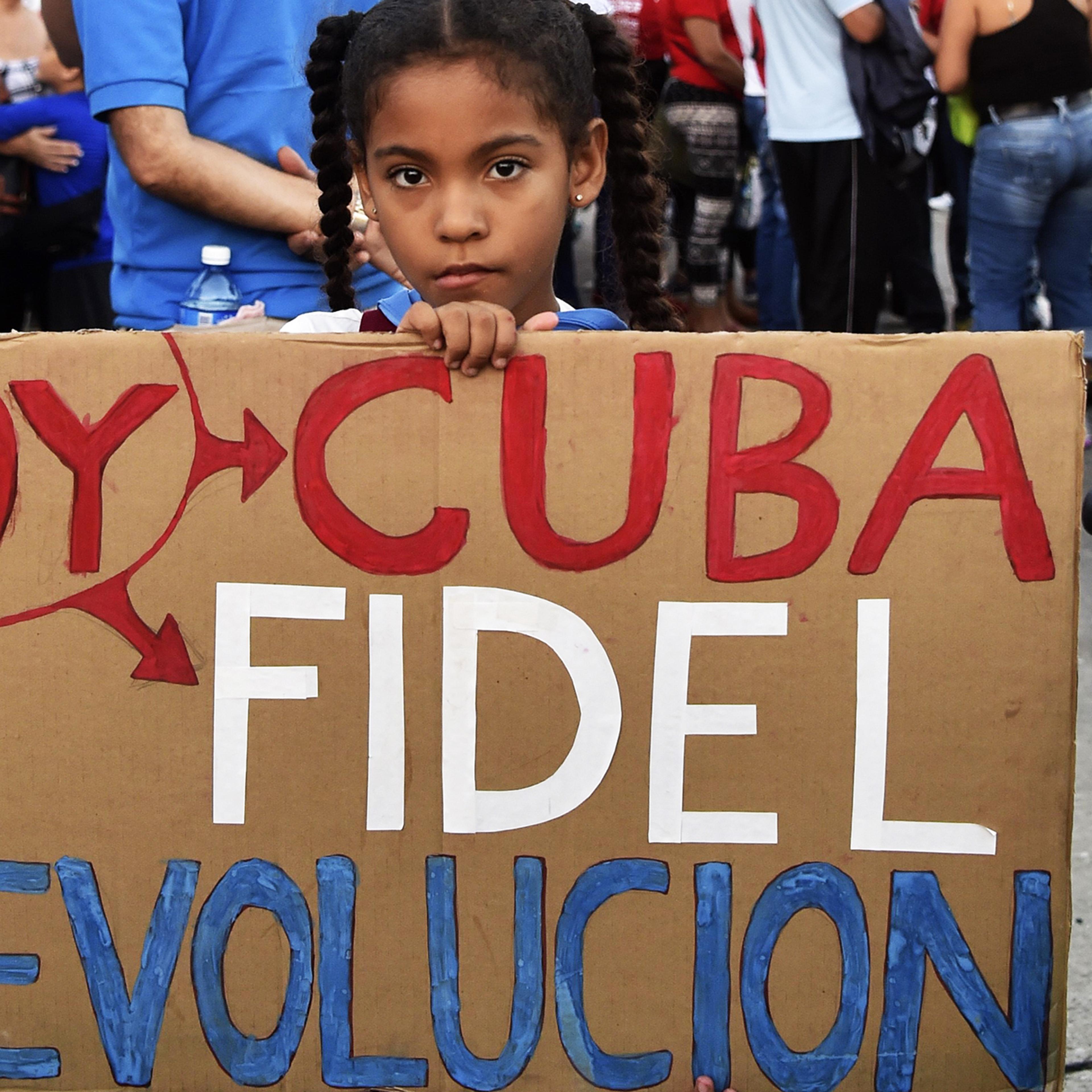A girl holds a sign reading "I am Cuba, Fidel, Revolution" as Cubans gather at Revolution Square to pay homage to Fidel Castro in Havana, on Nov. 29, 2016.