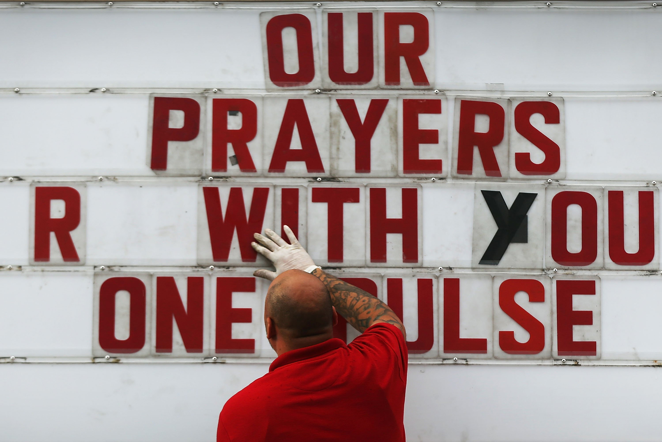 ORLANDO, FL - JUNE 16: Jiffy Lube employee Ralph Nieves put up a sign of support for the Orlando community following the shooting at the Pulse nightclub last Saturday night on June 16, 2016 in Orlando, Florida. Omar Mir Seddique Mateen shot the victims i