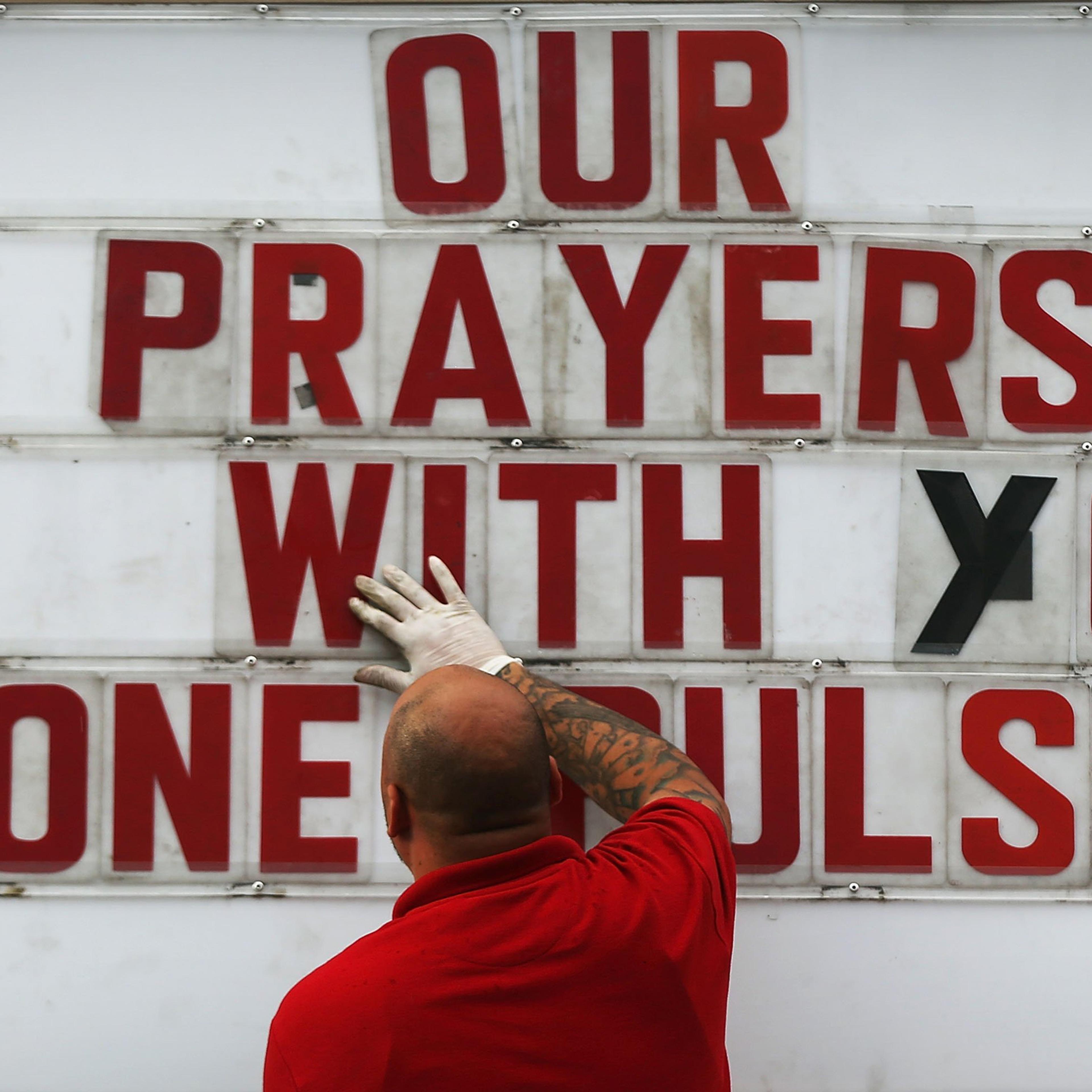 ORLANDO, FL - JUNE 16: Jiffy Lube employee Ralph Nieves put up a sign of support for the Orlando community following the shooting at the Pulse nightclub last Saturday night on June 16, 2016 in Orlando, Florida. Omar Mir Seddique Mateen shot the victims i