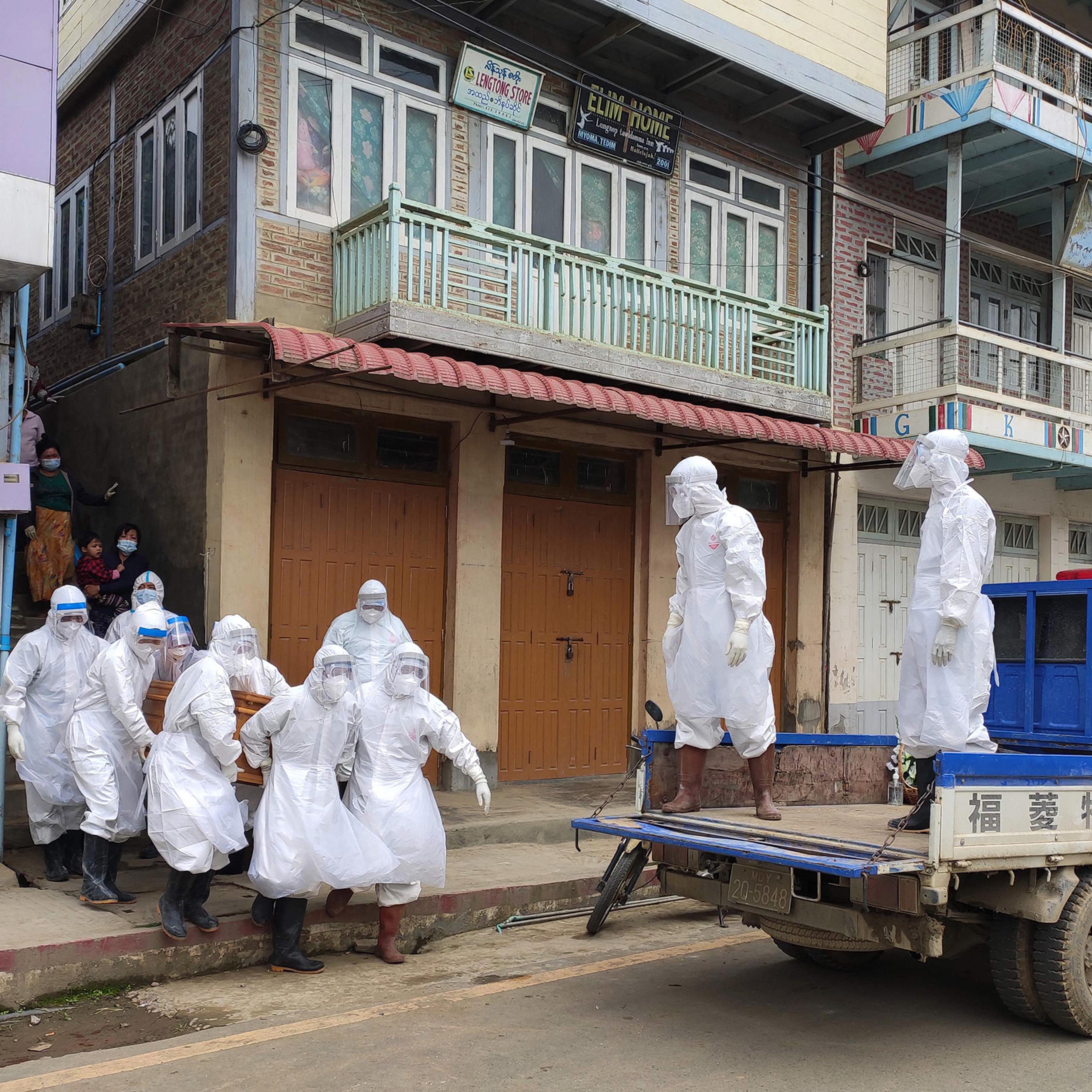 This handout photo from local media group Tedim Post taken and released on June 29, 2021, shows health workers carrying a coffin bearing the remains of a Covid-19 coronavirus victim who died at home in Tedim, western Chin state.