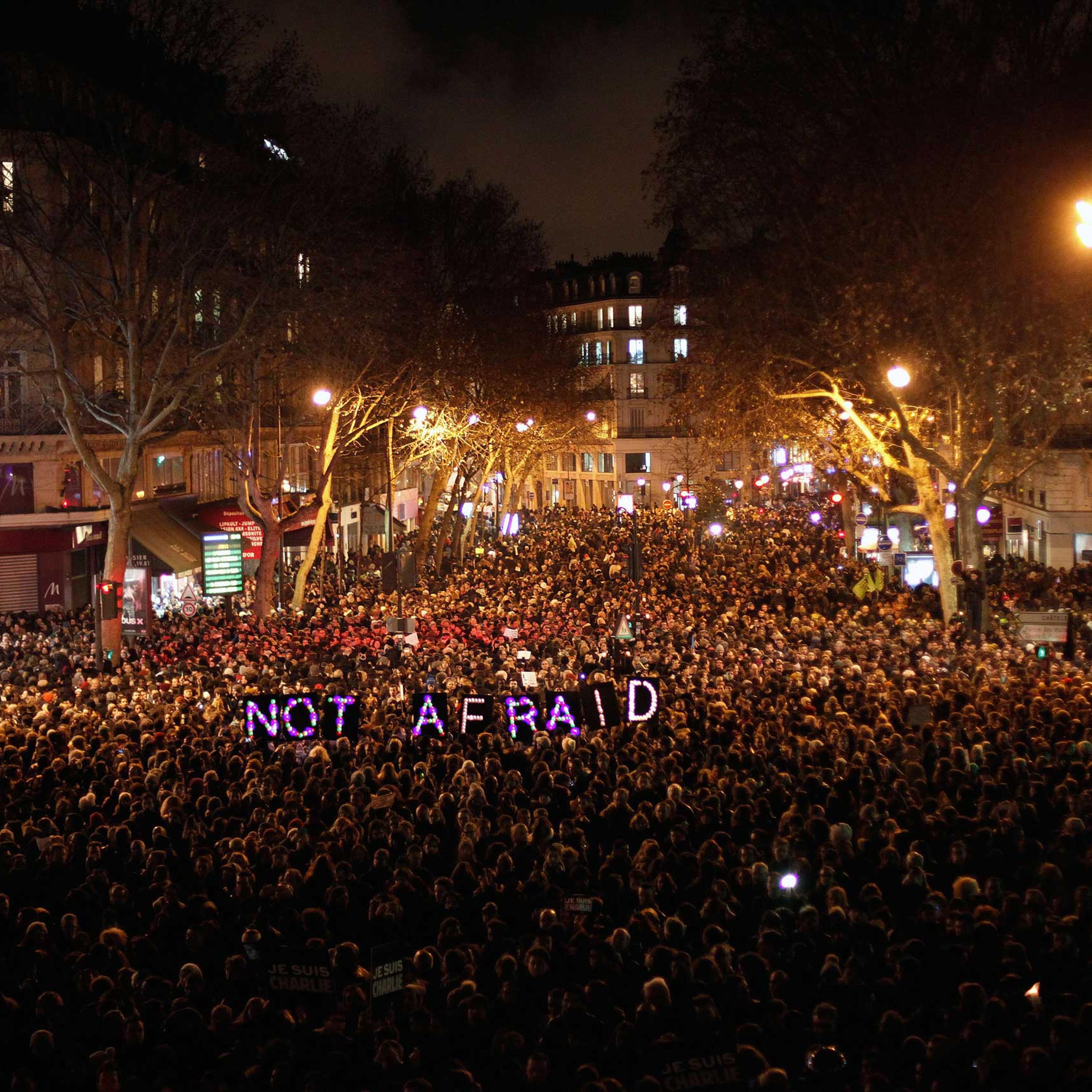 People gather to pay respect for the victims of a terror attack against a satirical newspaper, in Paris, Jan. 7, 2015.