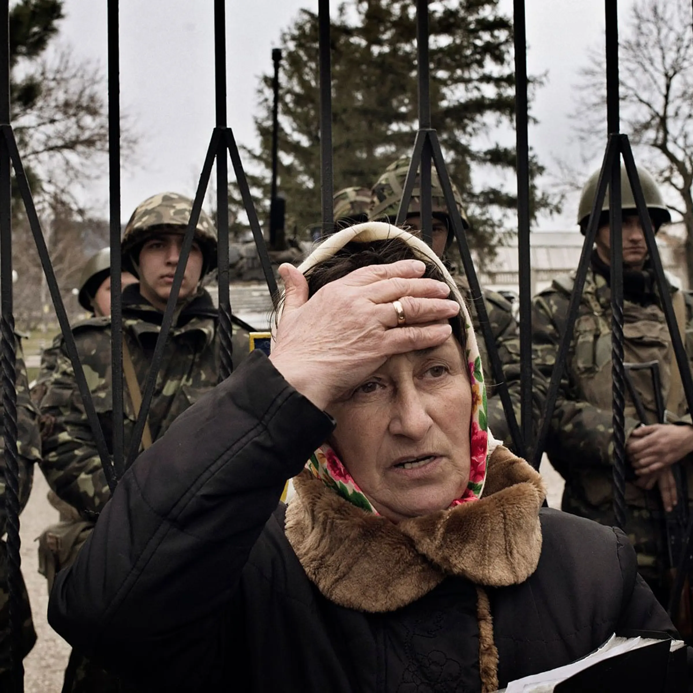 A Ukrainian woman reacts as troops in unmarked uniforms hold positions in Perevalnoye, a small Ukrainian base roughly 15 miles south of Simferopol on Sunday, March 2, 2014. About two dozen Ukrainian soldiers could be seen behind her.