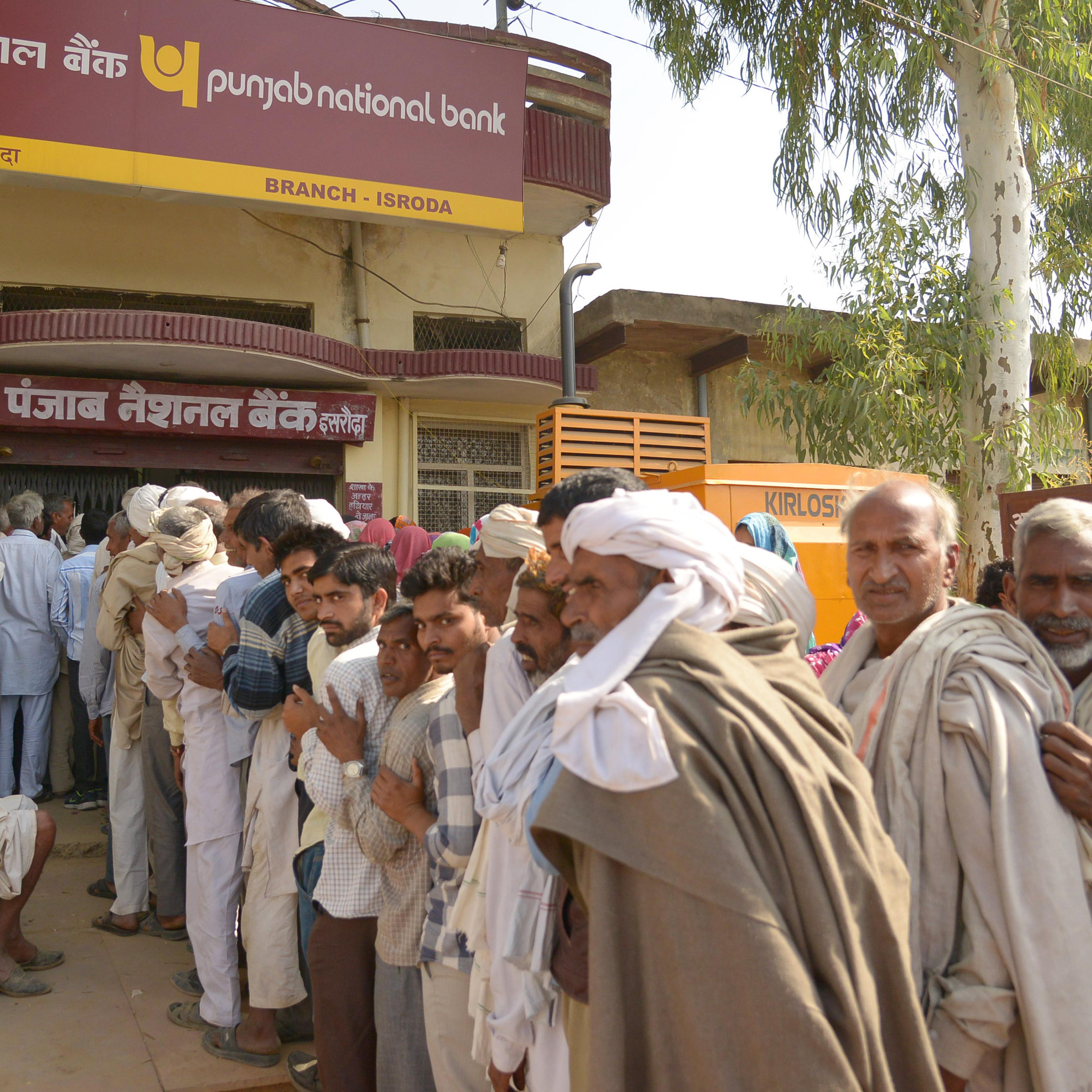 People stand on long queue for exchange Rupees 500 and 1000