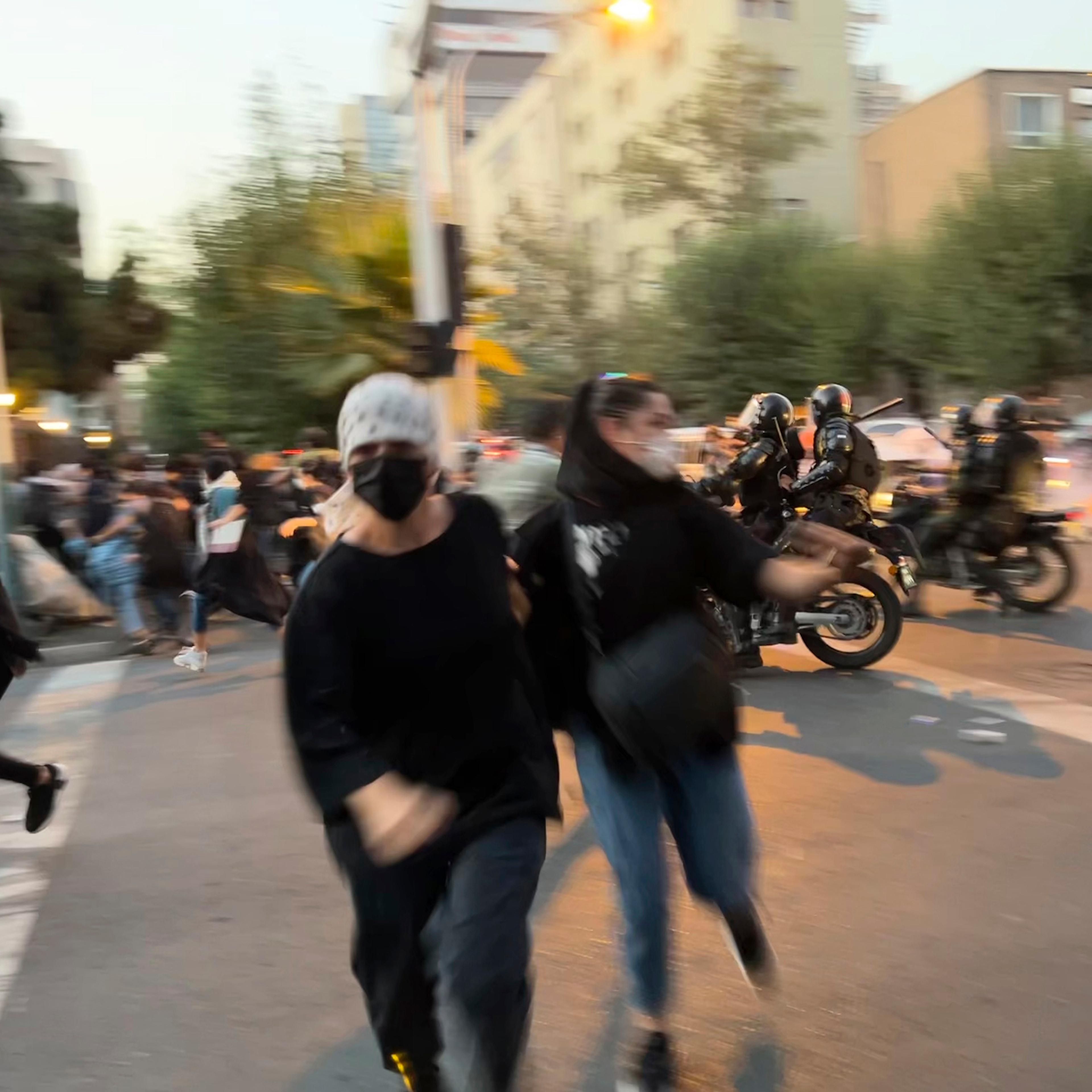 Women run away from anti-riot police during a protest of the death of a young woman, Mahsa Amini, who had been detained for violating the country's conservative dress code, in downtown Tehran on Sept. 19.