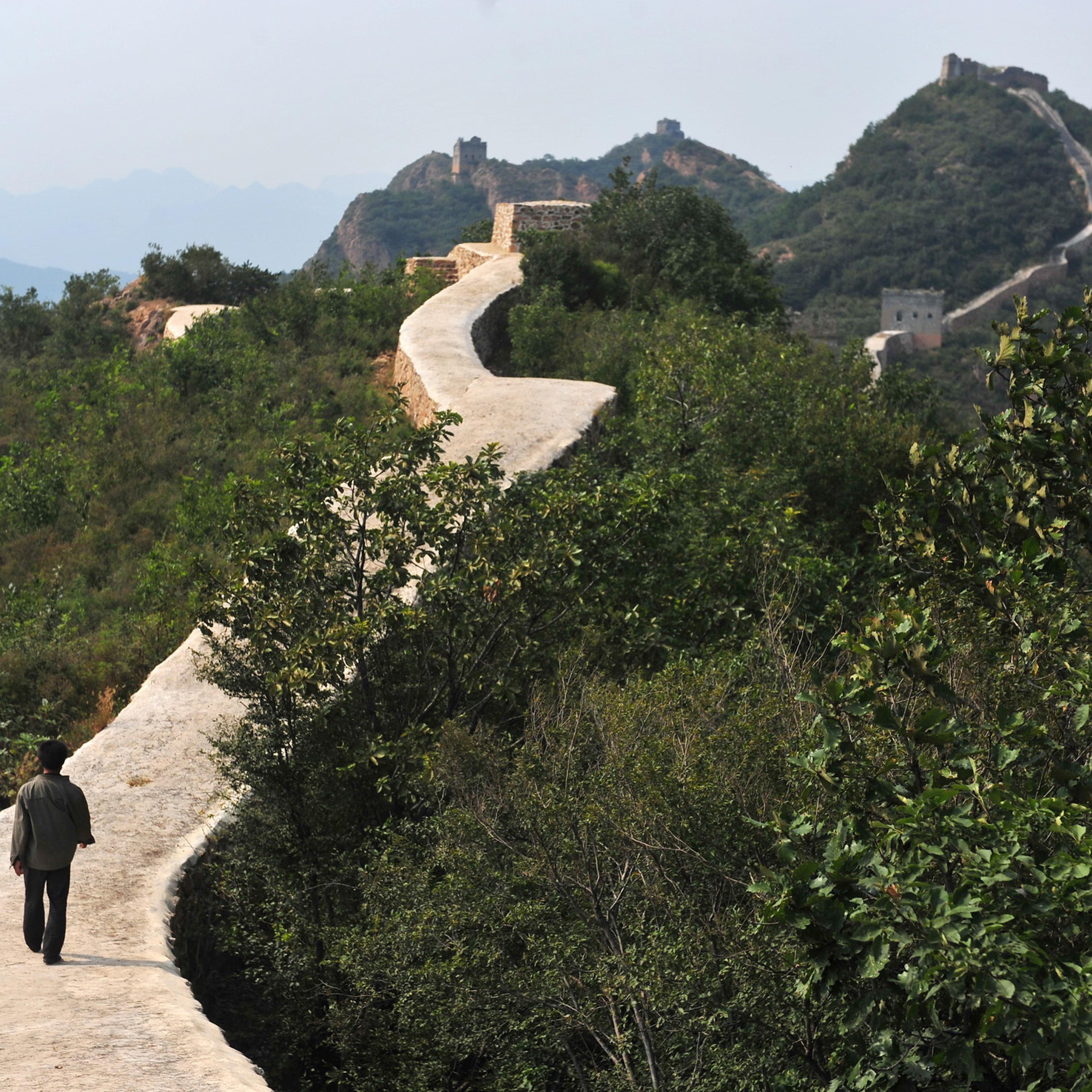 A Chinese farmer walks on a restored section of the Xiaohekou Great Wall, a wild stretch of the Great Wall, in Suizhong county, Huludao city, northeast China's Liaoning province, Sept. 21, 2016.