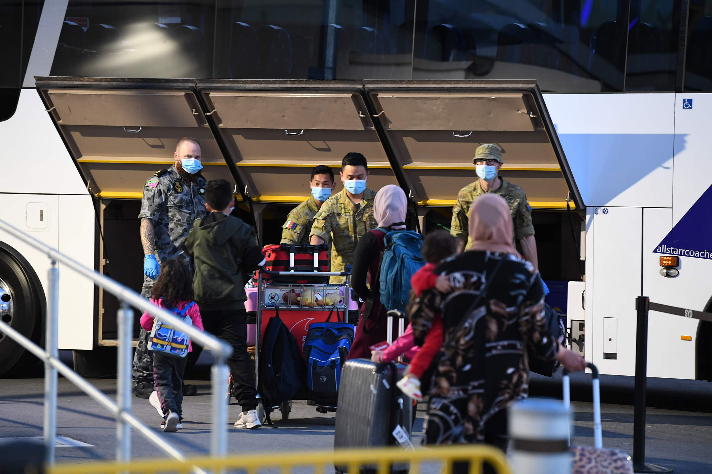 Passengers wearing face masks arrive to Sydney after a Qatar Airways flight on May 1, 2021. Australia banned flights from India earlier this week due to the escalating COVID-19 outbreak in India, but stranded Australians were still able to return on flig