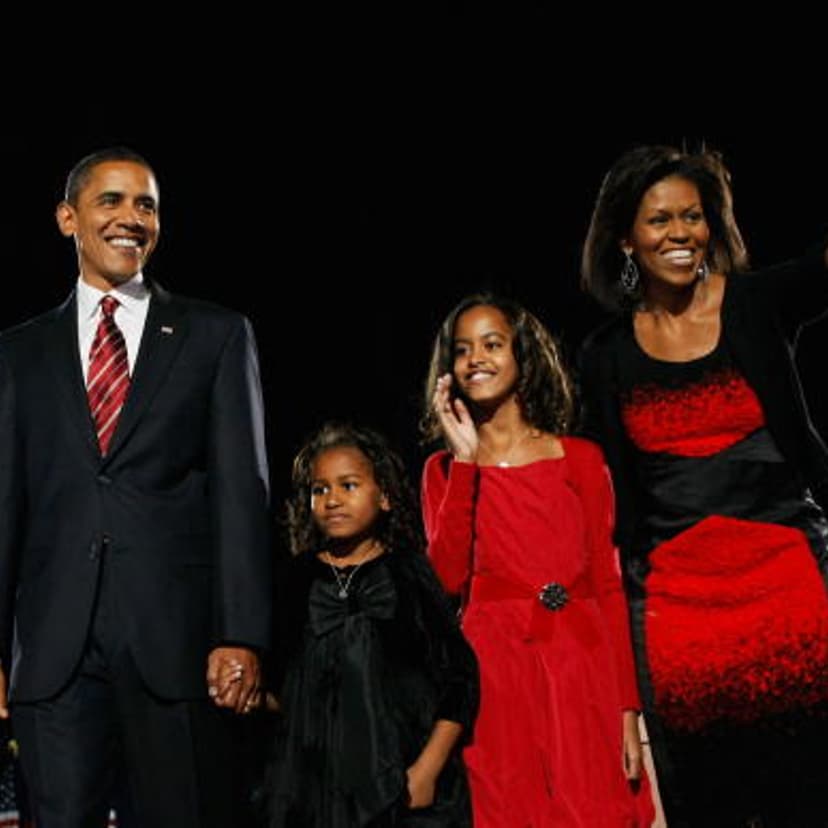 U.S. President elect Barack Obama stands on stage along with his wife Michelle and daughters Malia (red dress) and Sasha (black dress) during an election night gathering in Grant Park on November 4, 2008 in Chicago, Illinois.