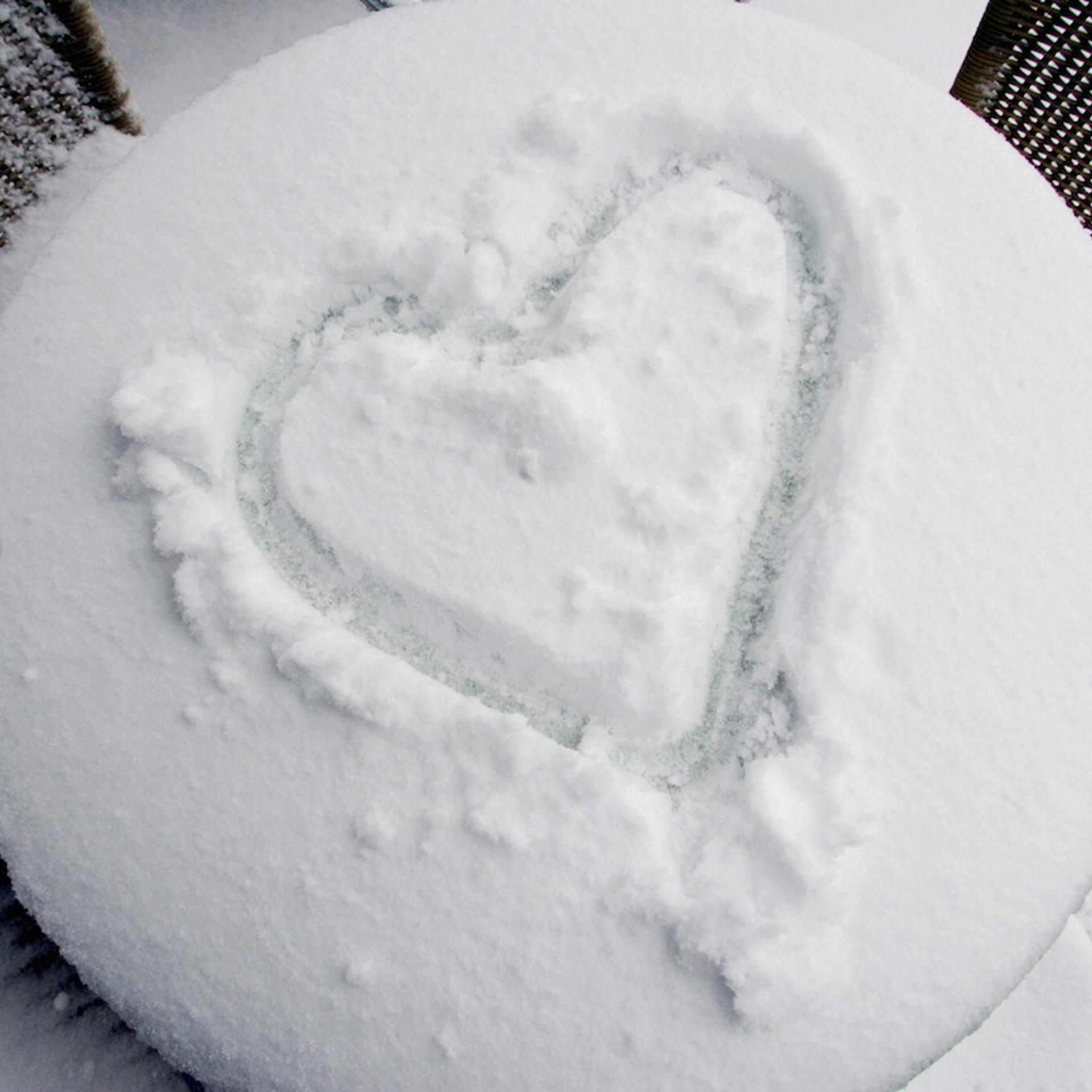 A heart is painted in the snow on a tabl