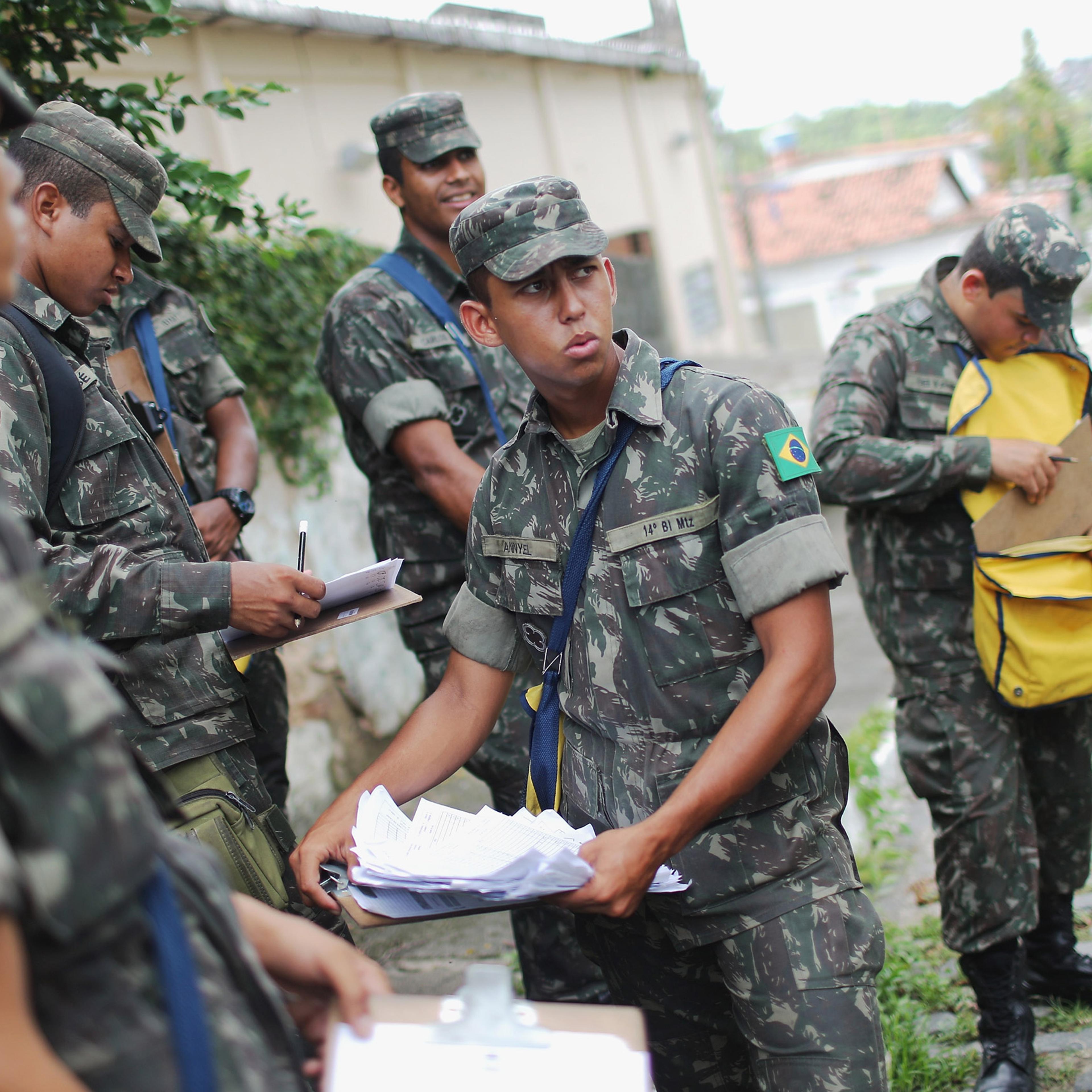 RECIFE, BRAZIL - JANUARY 30: Brazilian Army soldiers gather while canvassing a neighborhood informing the public of preventive methods and searching for potential breeding grounds in an effort to eradicate the mosquitos which transmit the Zika virus on J