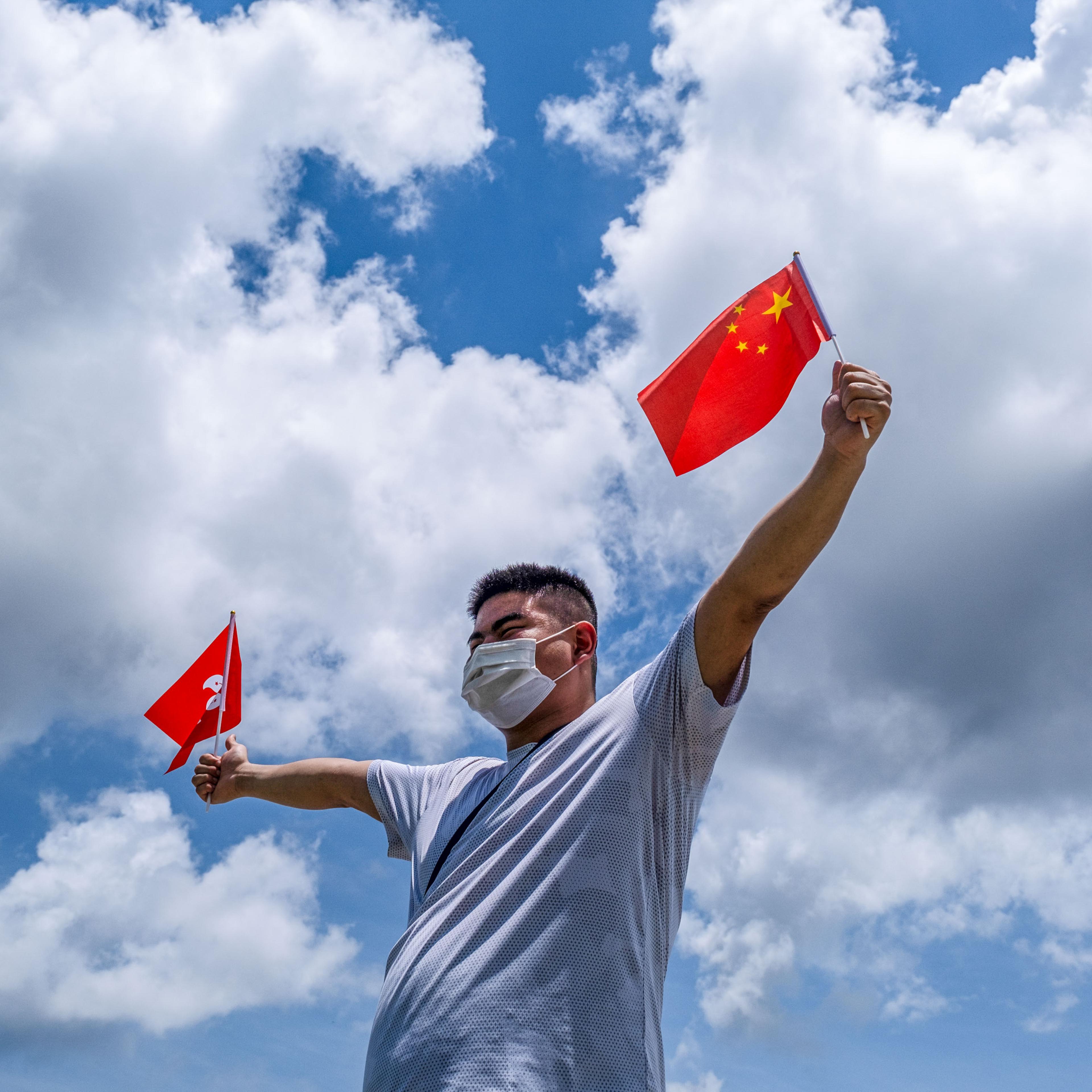 Pro-China supporter waves Chinese and Hong Kong flags during