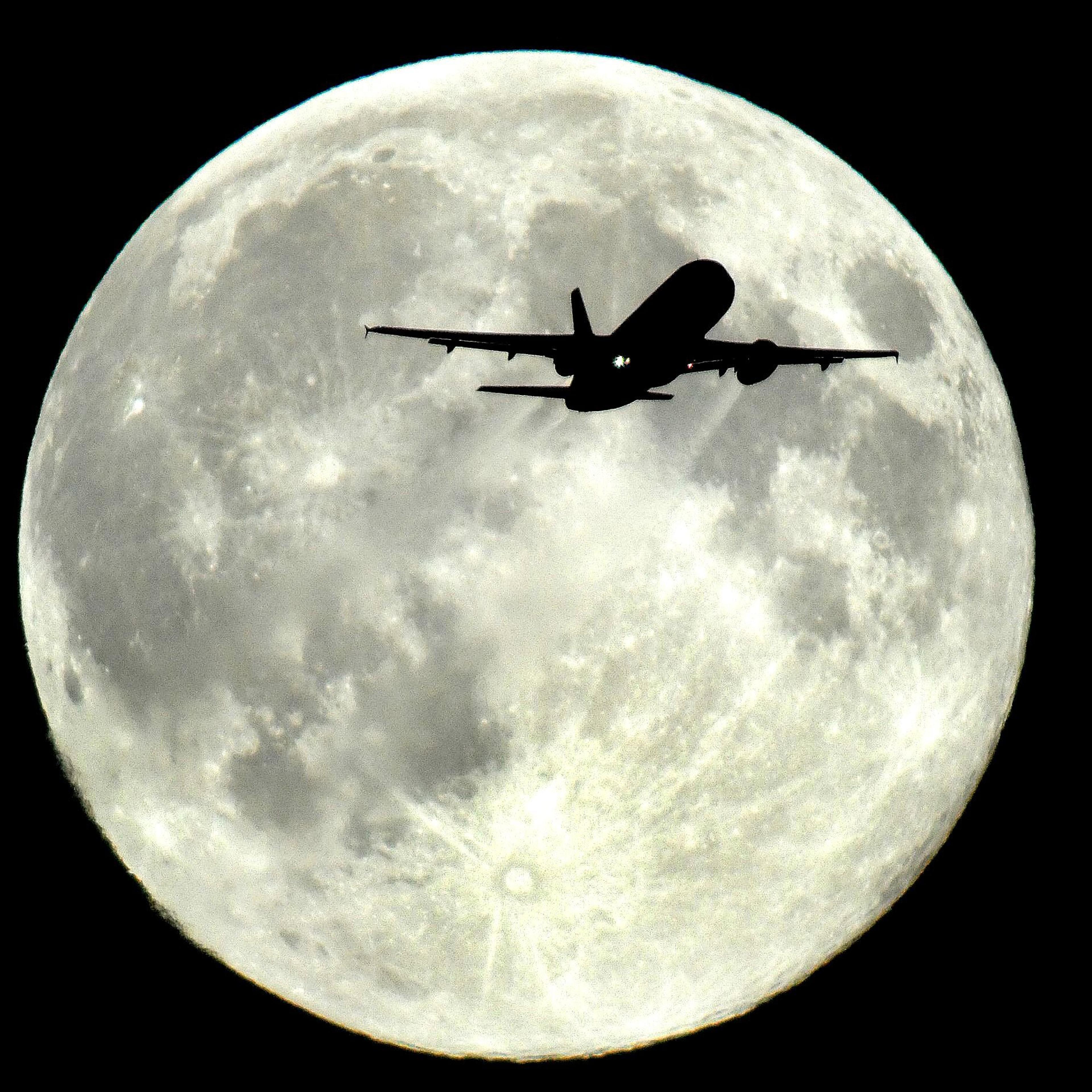 A plane flies in front of a supermoon above Westminster in London enroute to Heathrow airport on August 10, 2014.