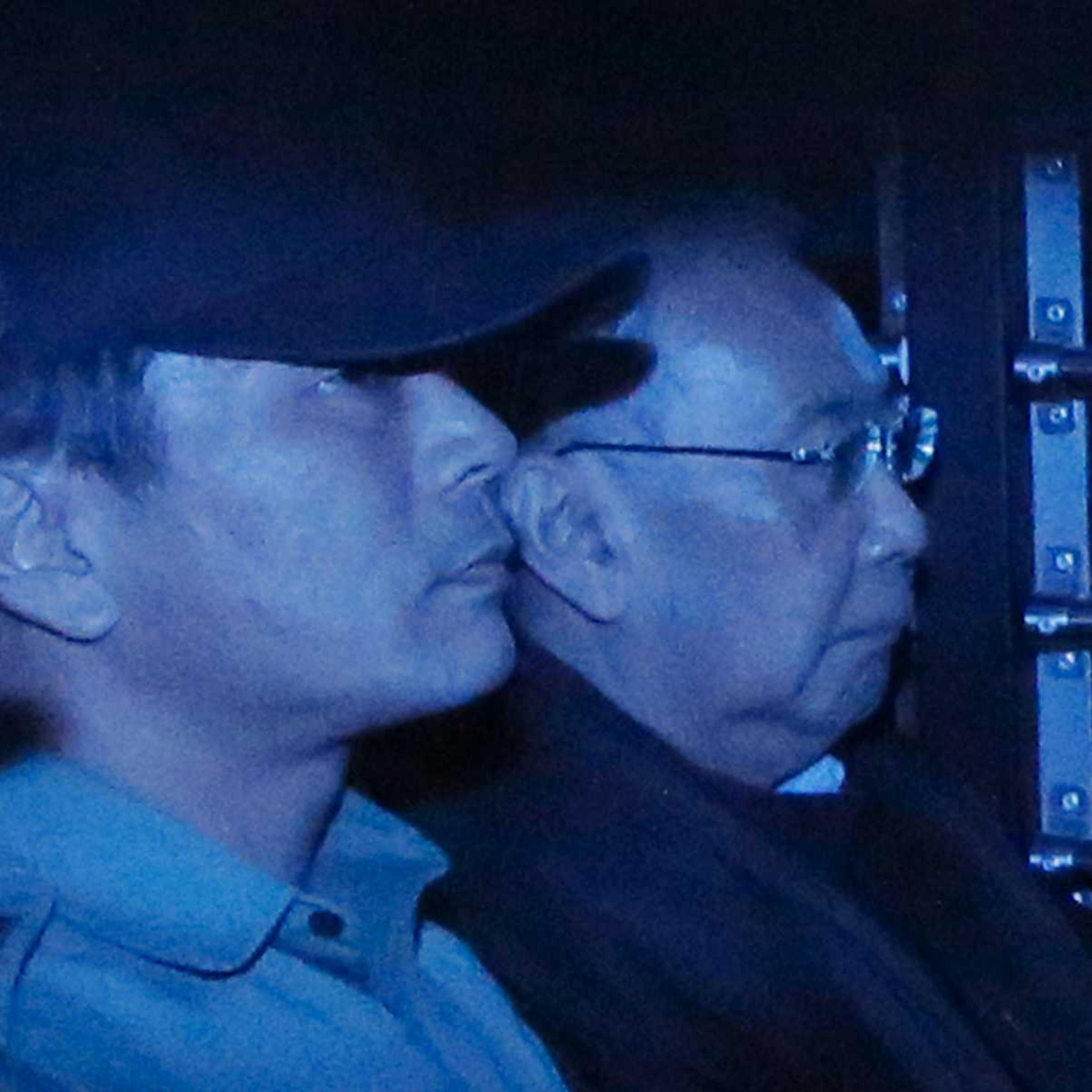 In this photo taken through a tinted glass, former Hong Kong Chief Secretary Rafael Hui, right, is escorted by a staff member from Hong Kong Correctional Services inside a van outside the High Court in Hong Kong on Dec. 19, 2014
