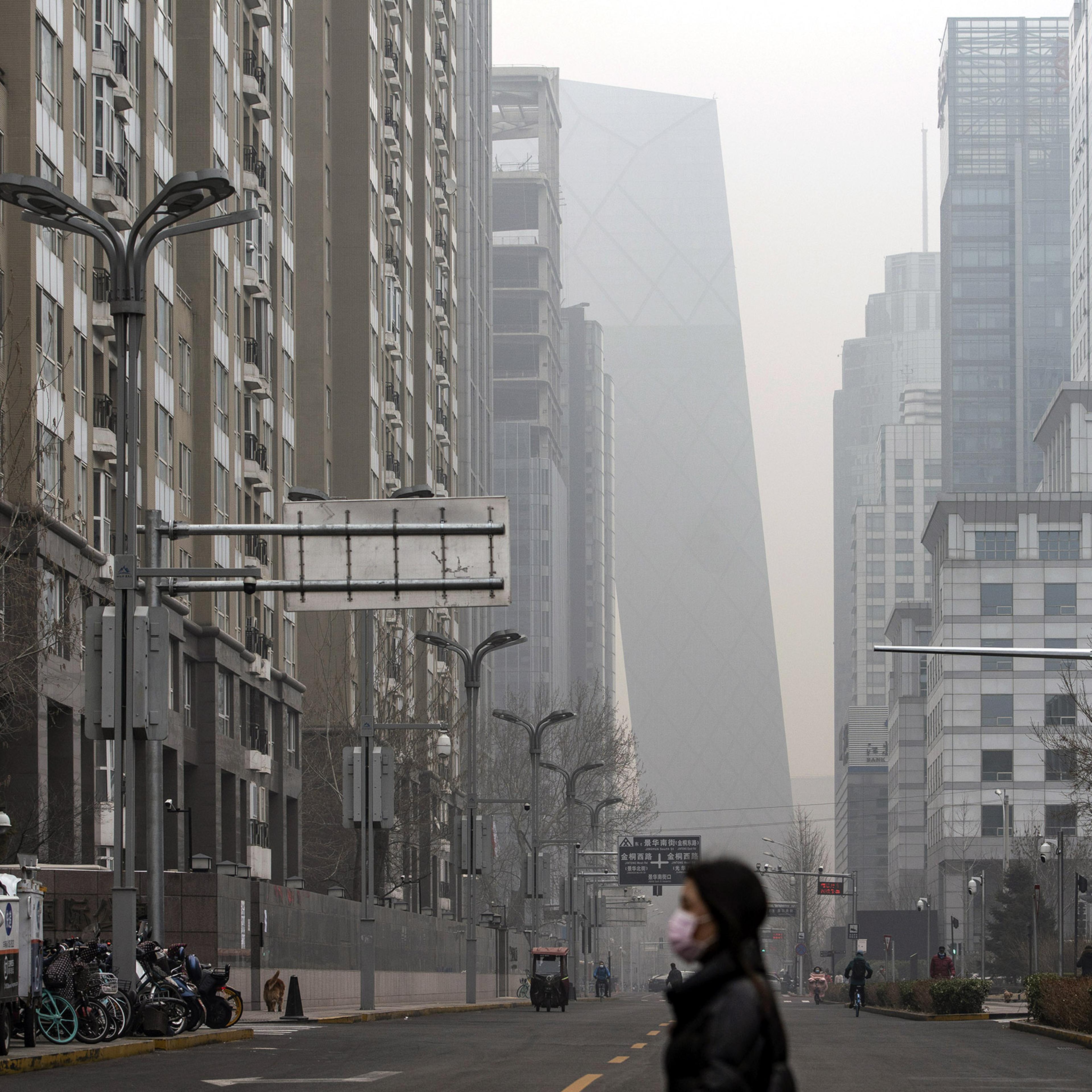 A pedestrian walks in Beijing, shrouded in smog, on March 5, 2021.