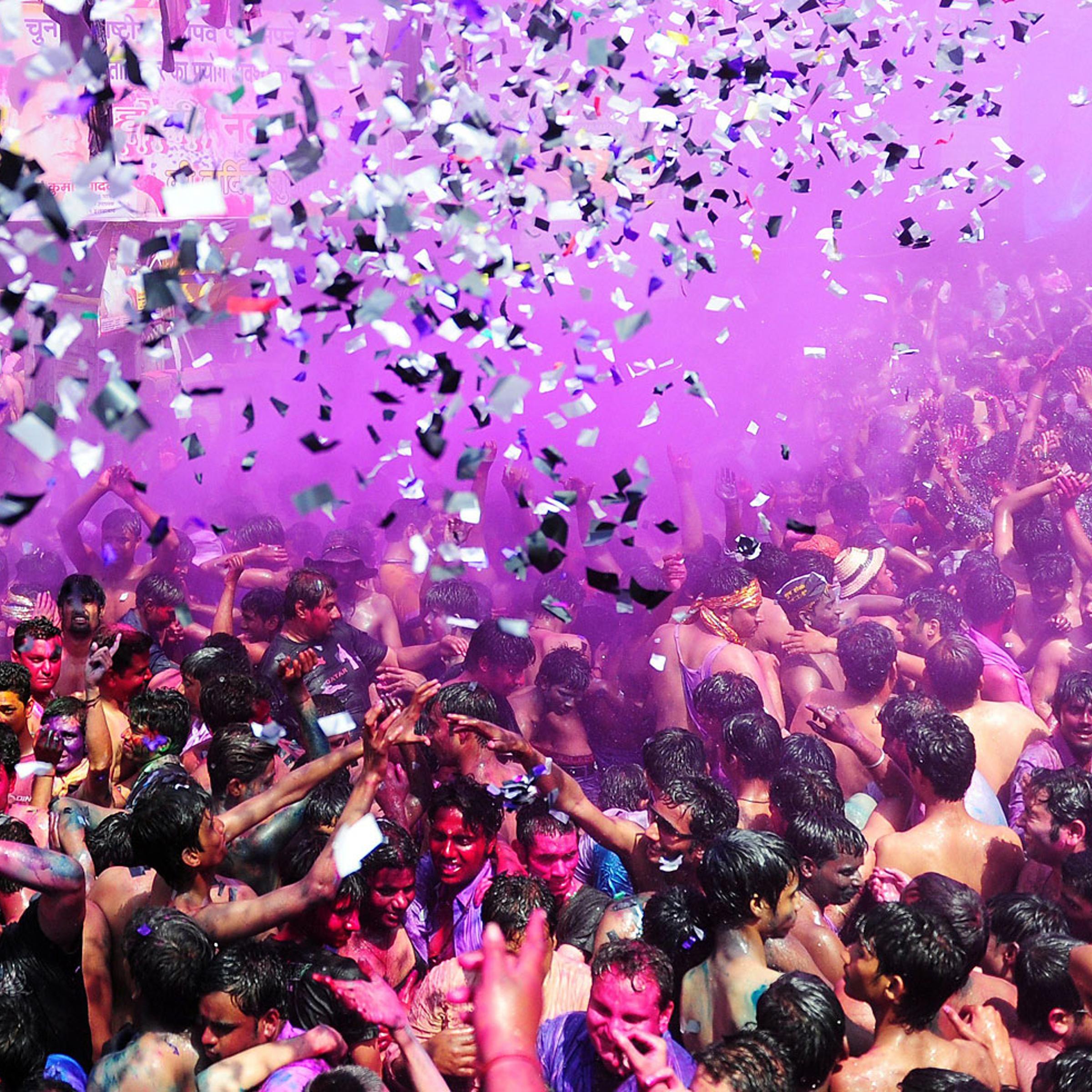 Indian revellers covered in coloured powder dance during Holi festival celebrations in Allahabad on March 17, 2014.