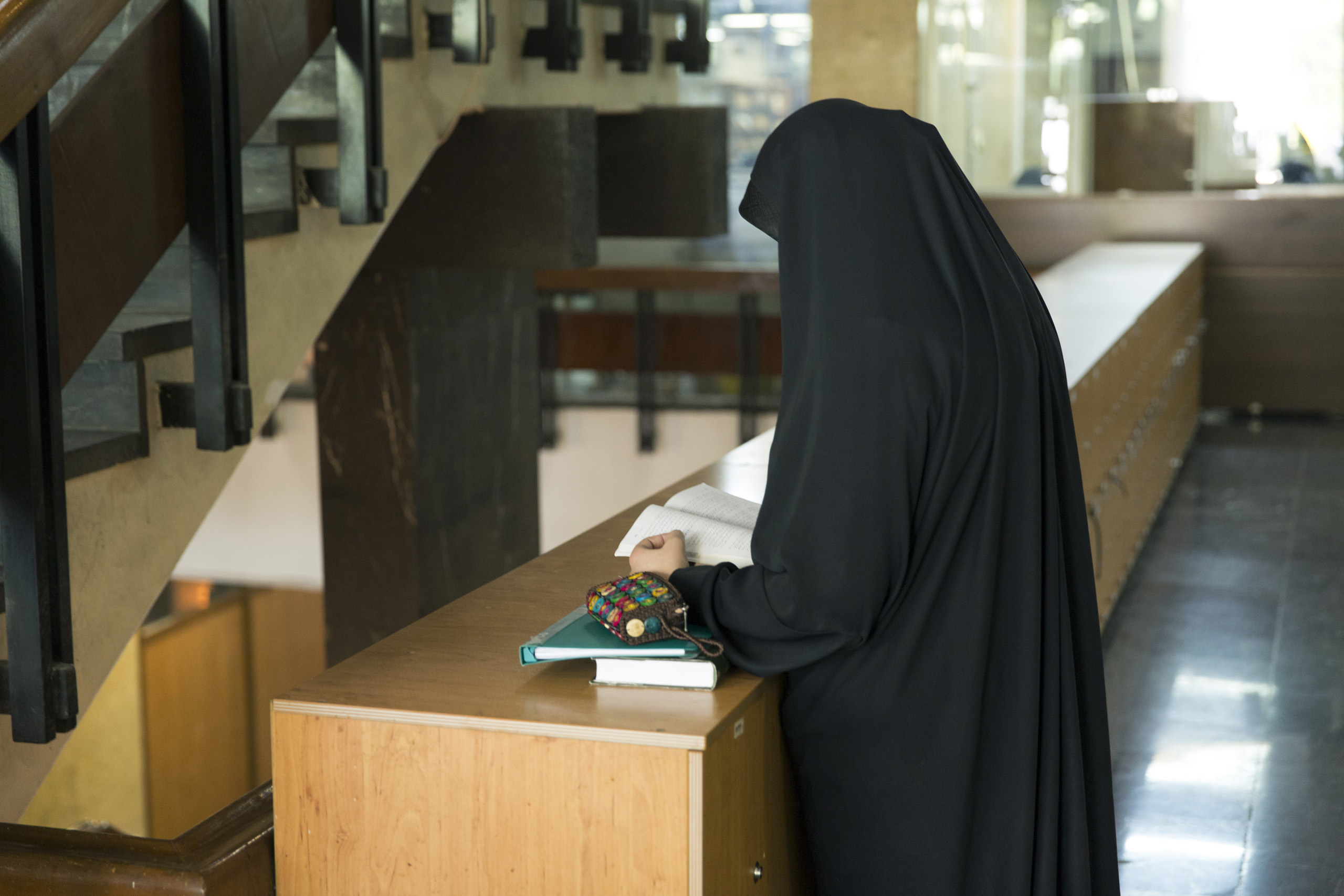 A veiled female student reading a book at the University of Tehran on October 18, 2015.