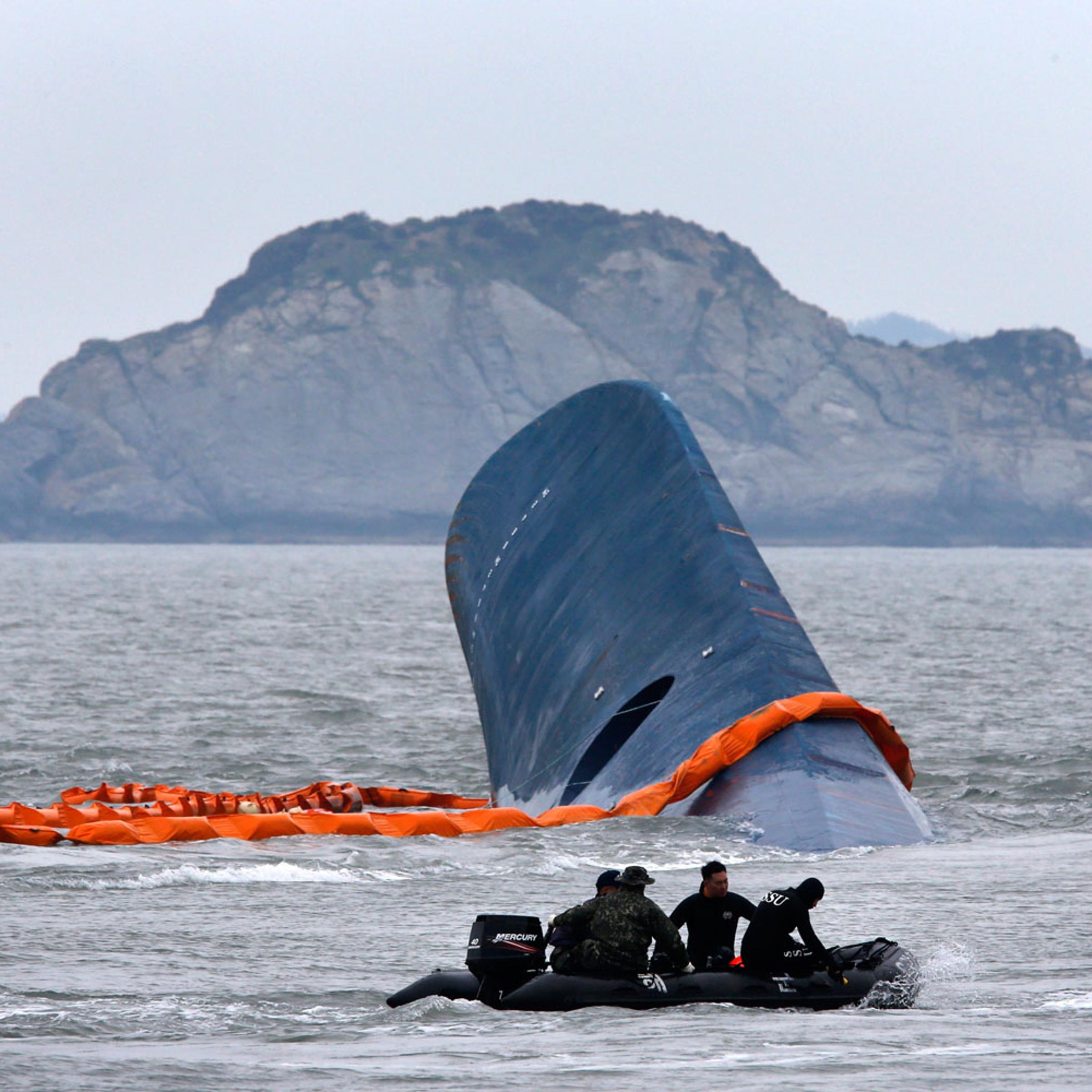 A dinghy involved in salvage operations passes near the upturned South Korean ferry <i>Sewol</i> in the sea off Jindo, South Korea, on April 17, 2014