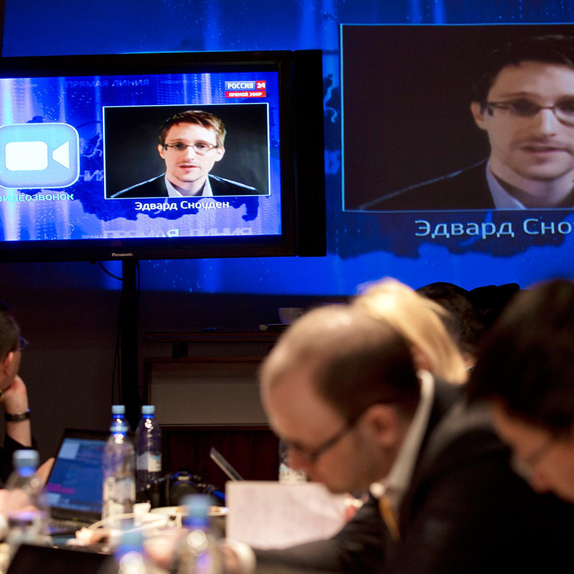 Edward Snowden, displayed on television screens, asks a question to Russian President Vladimir Putin during a nationally televised question-and-answer session, in Moscow, Thursday, April 17, 2014.