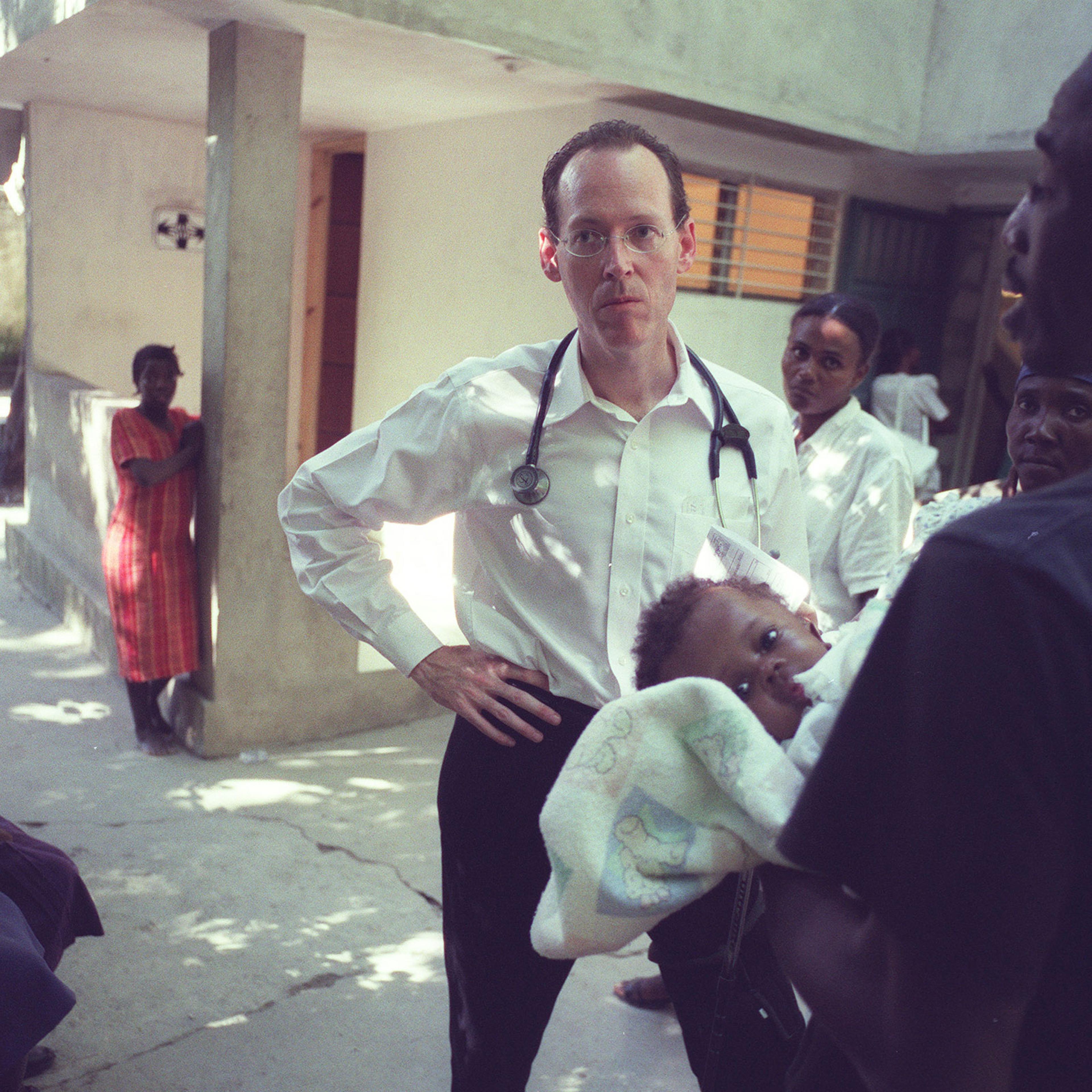 Dr. Paul Farmer listens to a man seeking treatment for his daughter at the Partners in Health hospital in Cange, Haiti, Nov. 2003. (Angel Franco/The New York Times)