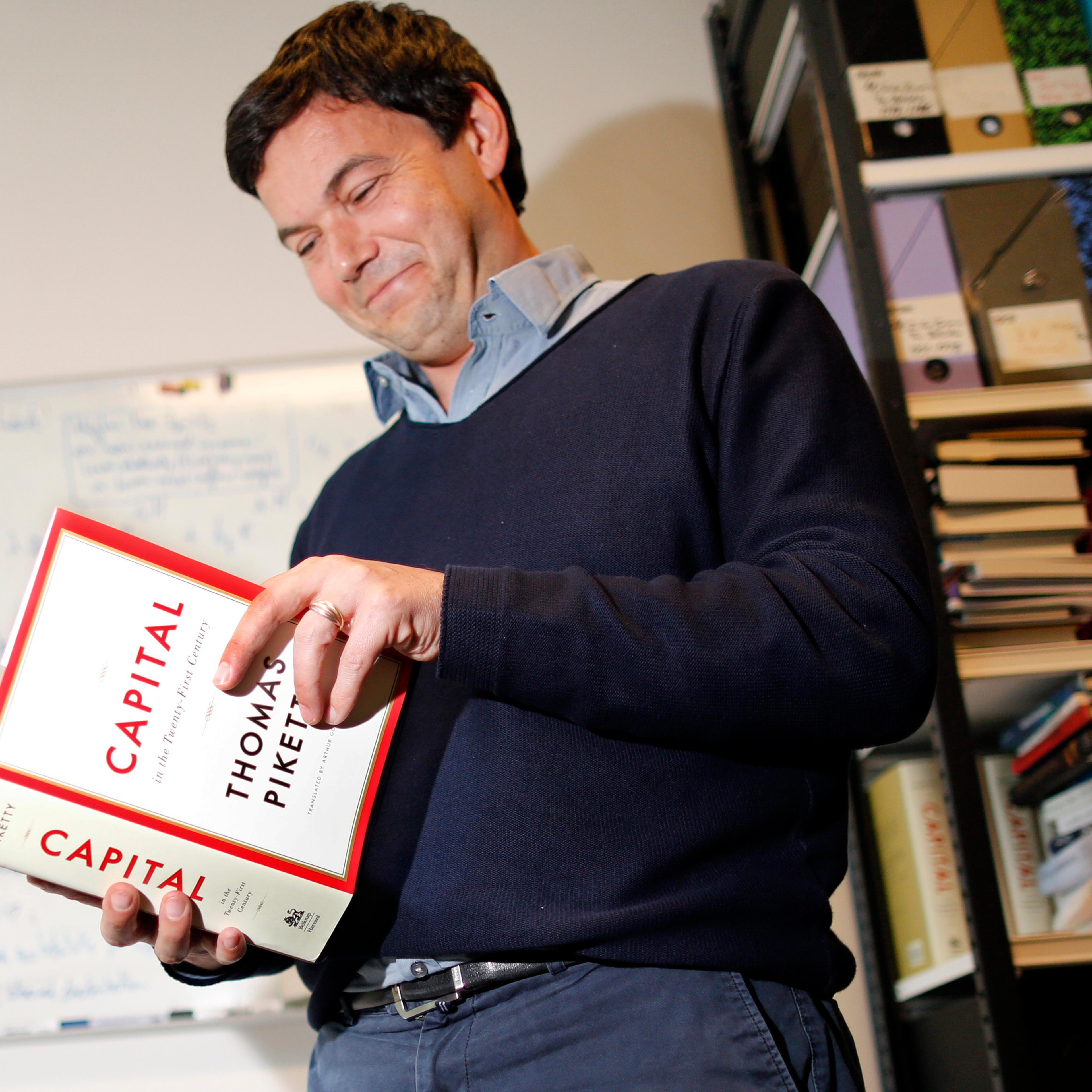 Thomas Piketty, French economist and academic, poses in his book-lined office at the French School for Advanced Studies in the Social Sciences (EHESS), in Paris