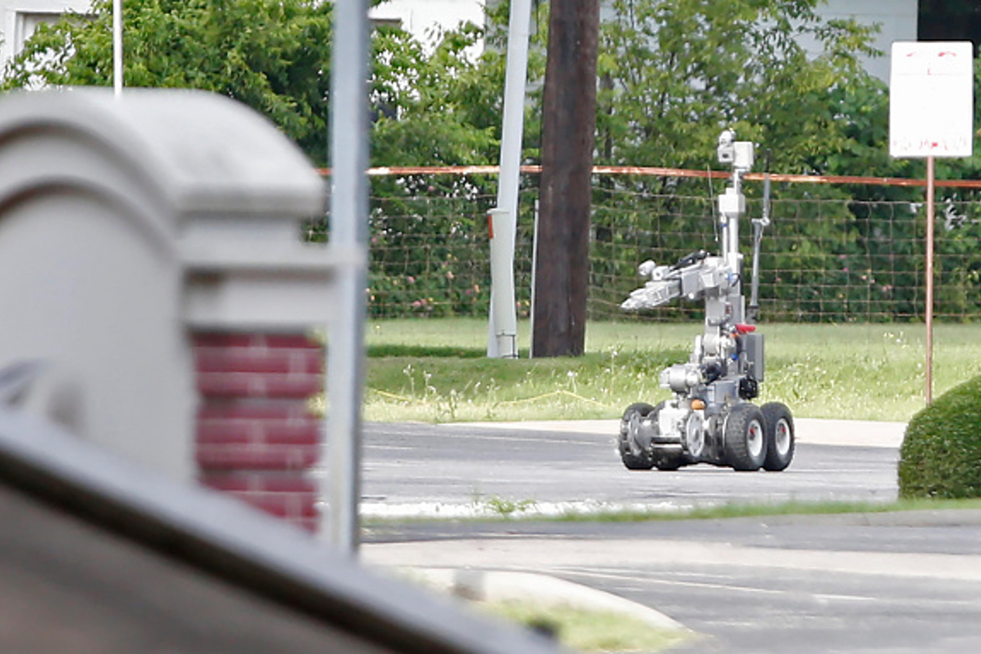 Dallas Police use a robot to gain access to an armored van, which authorities believed was rigged with explosives, and was driven by a suspect who attacked Dallas Police Headquarters in Dallas, Texas, June 13, 2015.