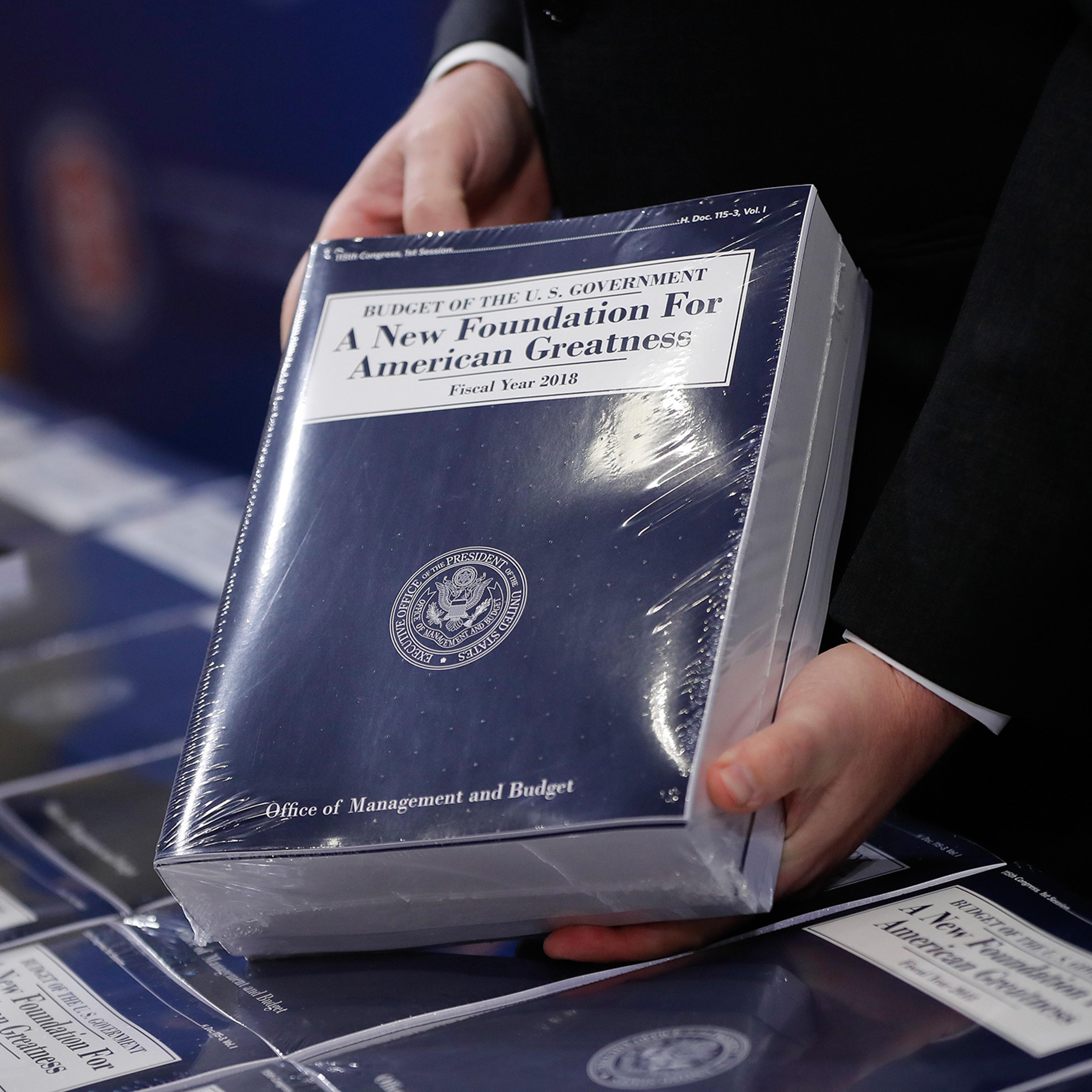Eric Ueland, Republican staff director, Senate Budget Committee holds a copy of President Donald Trump's fiscal 2018 federal budget, before distributing them to congressional staffers on Capitol Hill in Washington, Tuesday, May 23, 2017.