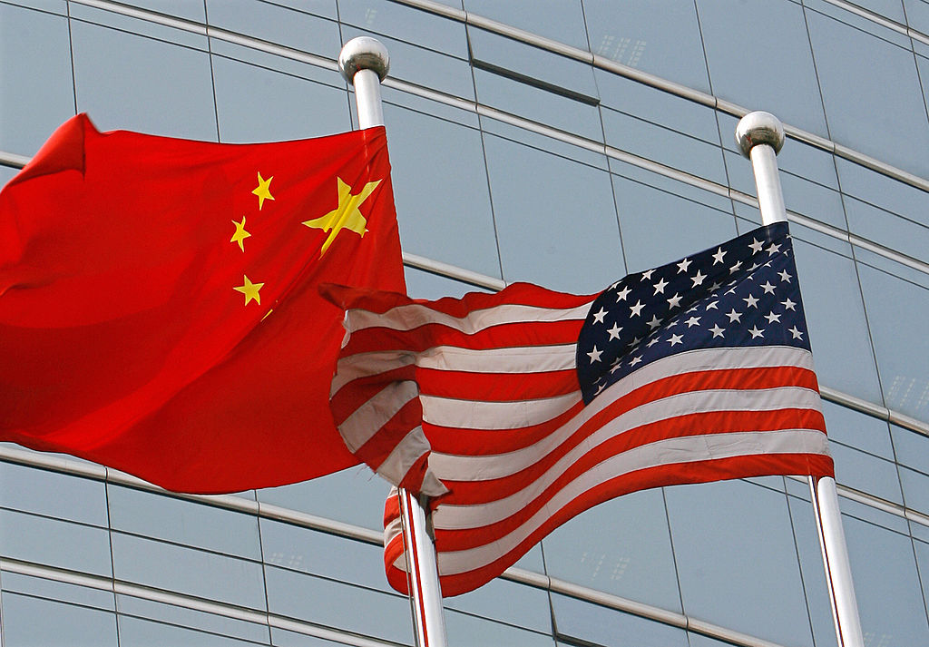 A US and a Chinese flag wave outside a c
