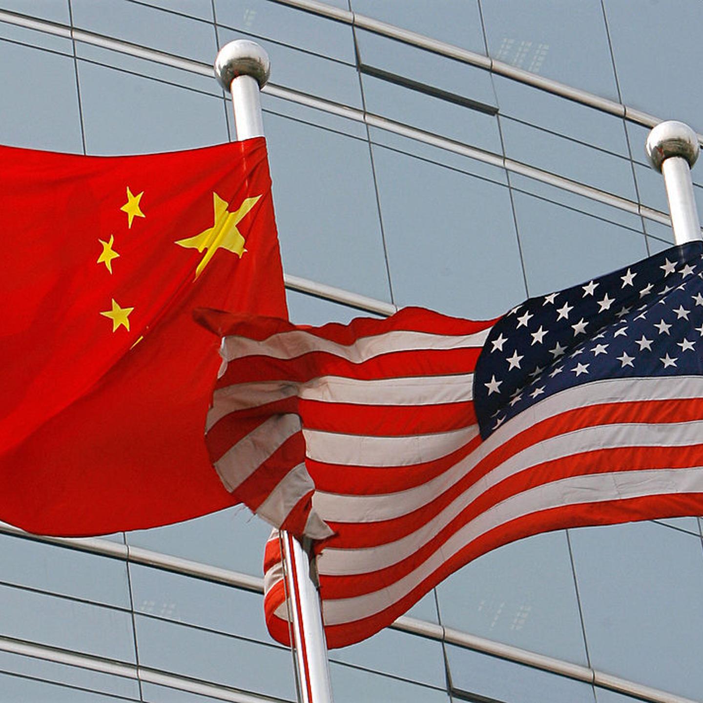 A US and a Chinese flag wave outside a c