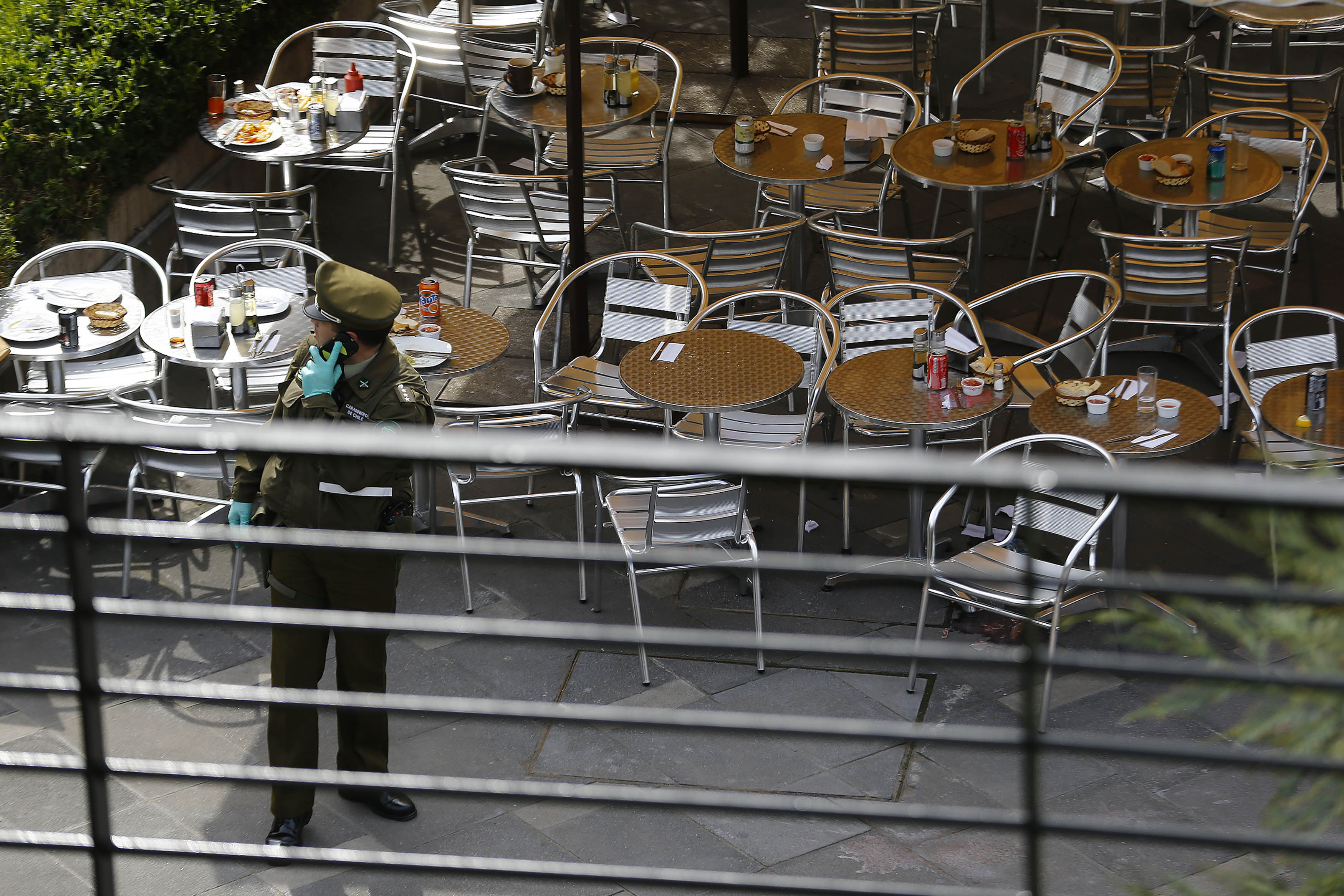 A police officer talks on his cell phone at the area where a bomb exploded in Santiago
