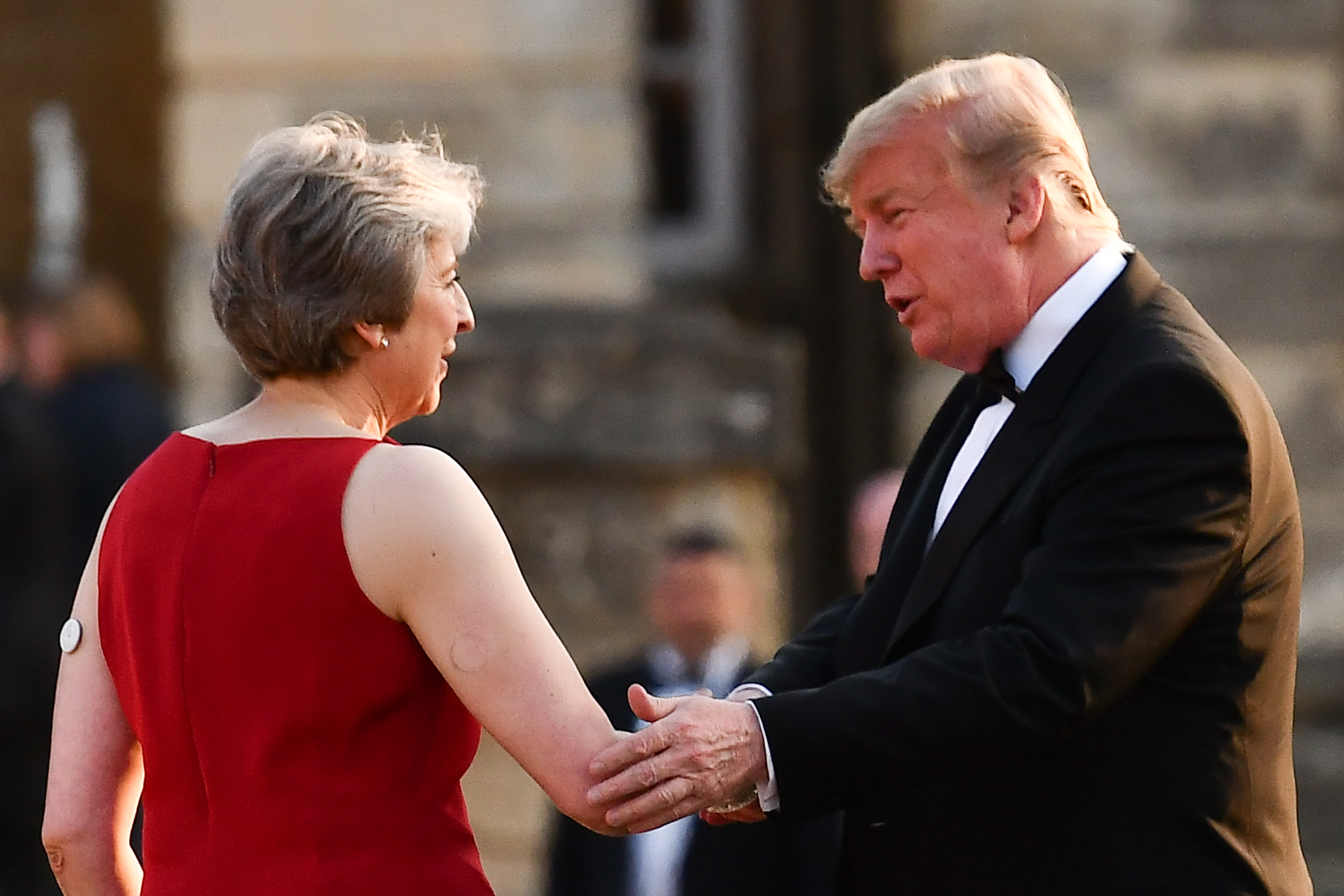 Trump and Theresa May shaking hands at dinner in England