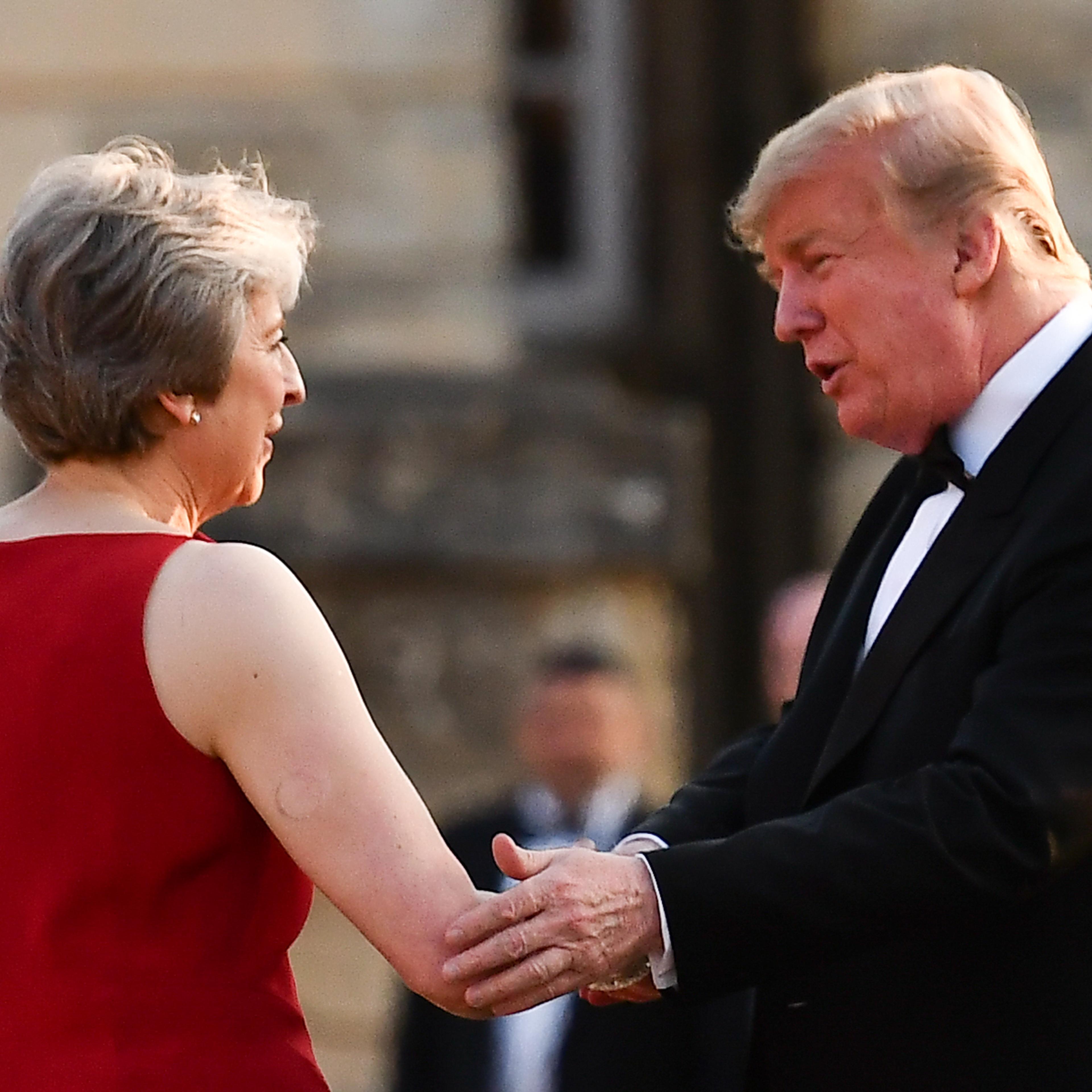 Trump and Theresa May shaking hands at dinner in England