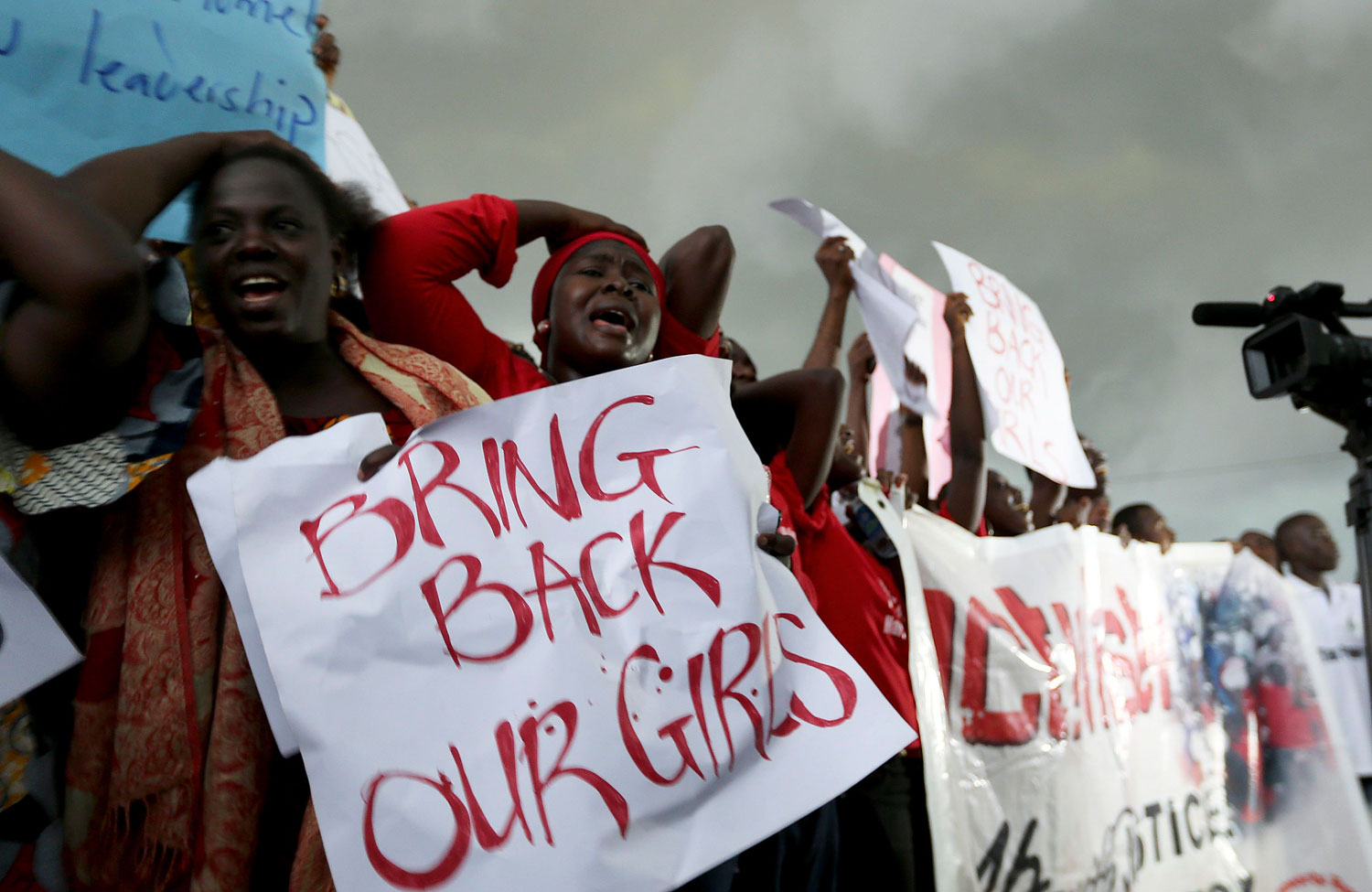Women react during a protest demanding security forces to search harder for 200 abducted schoolgirls, outside Nigeria's parliament in Abuja