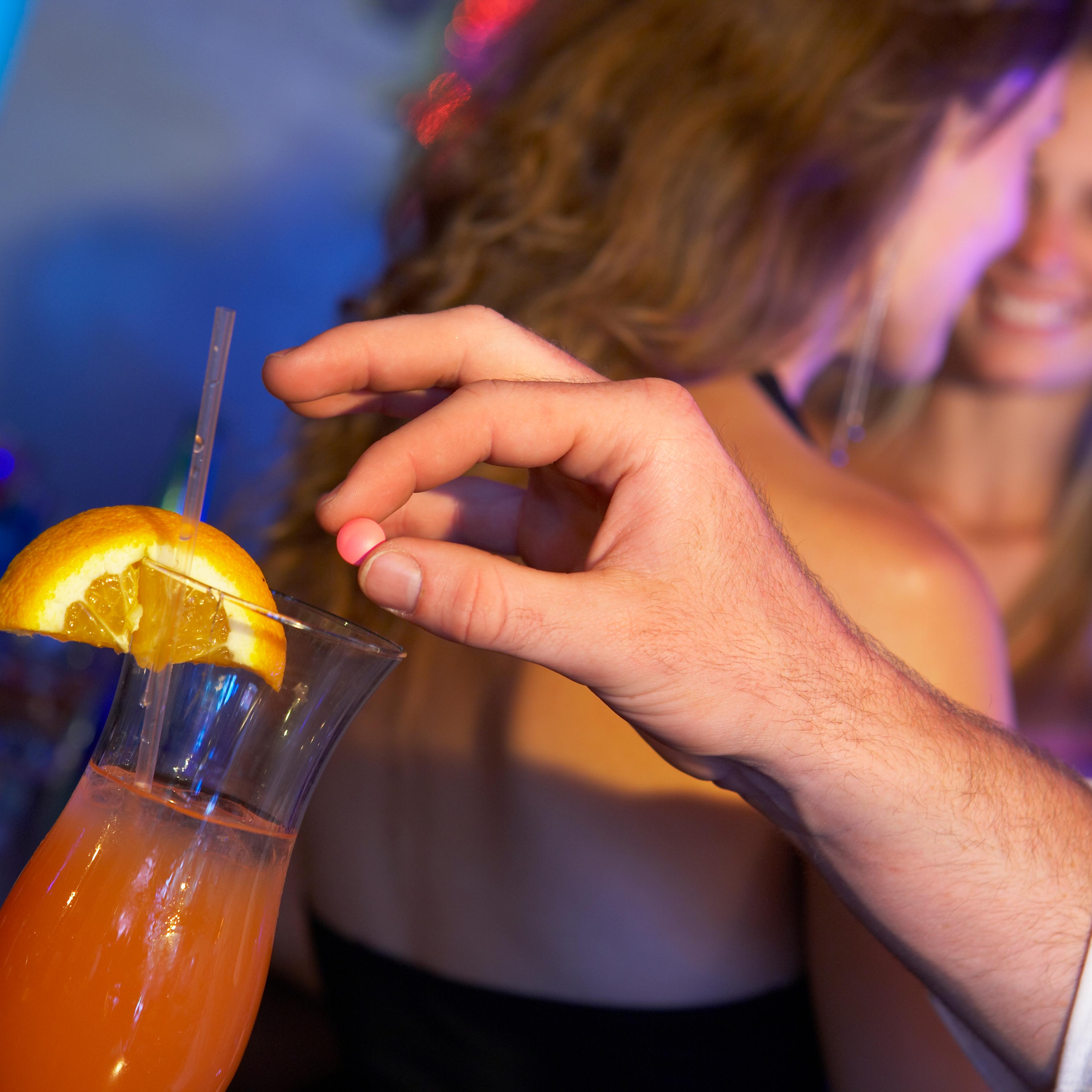 Man Drugging Woman's Drink In Bar
